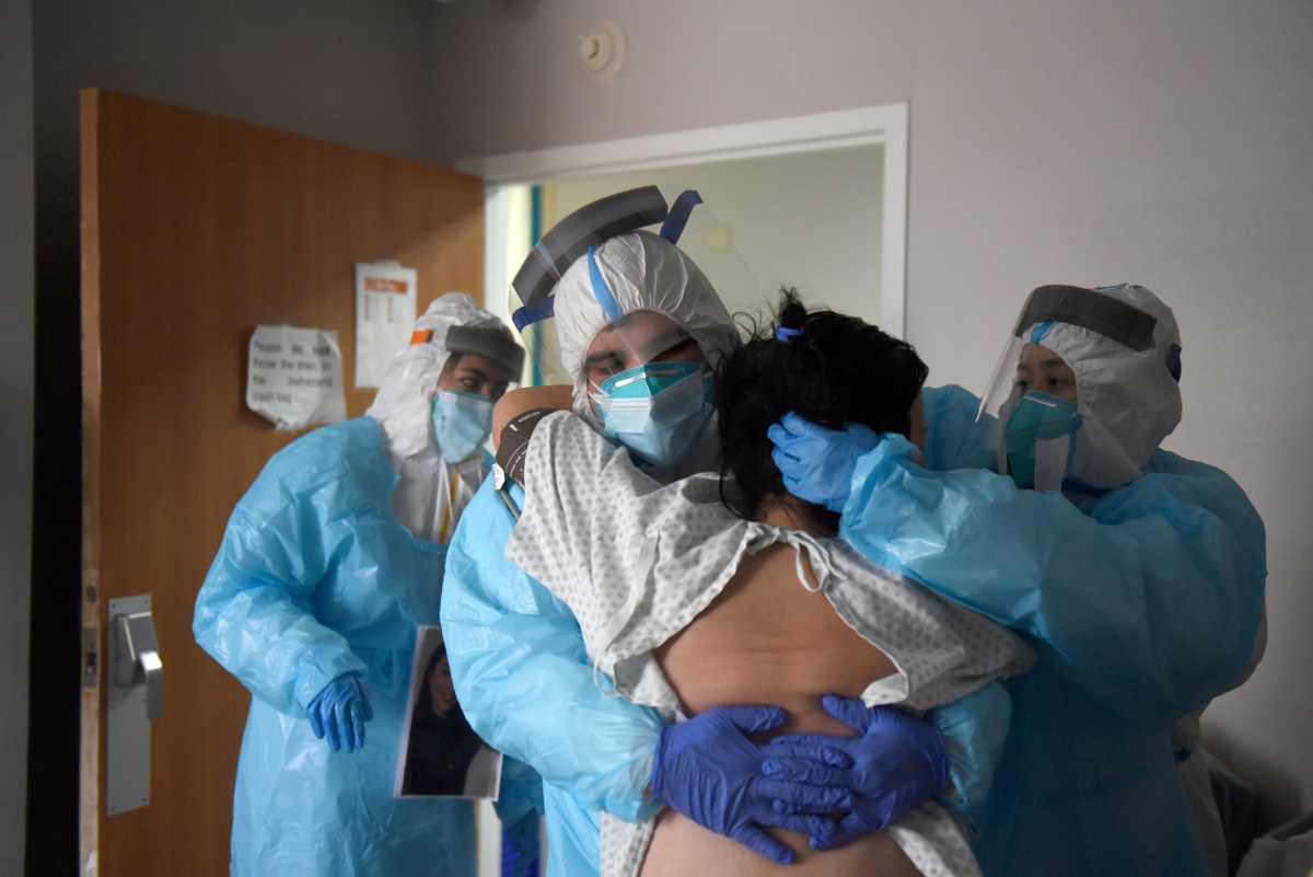 Alonso Lugo helps a patient try to stand inside the coronavirus disease (COVID-19) unit at United Memorial Medical Center in Houston, Texas, U.S., December 30, 2020.  REUTERS