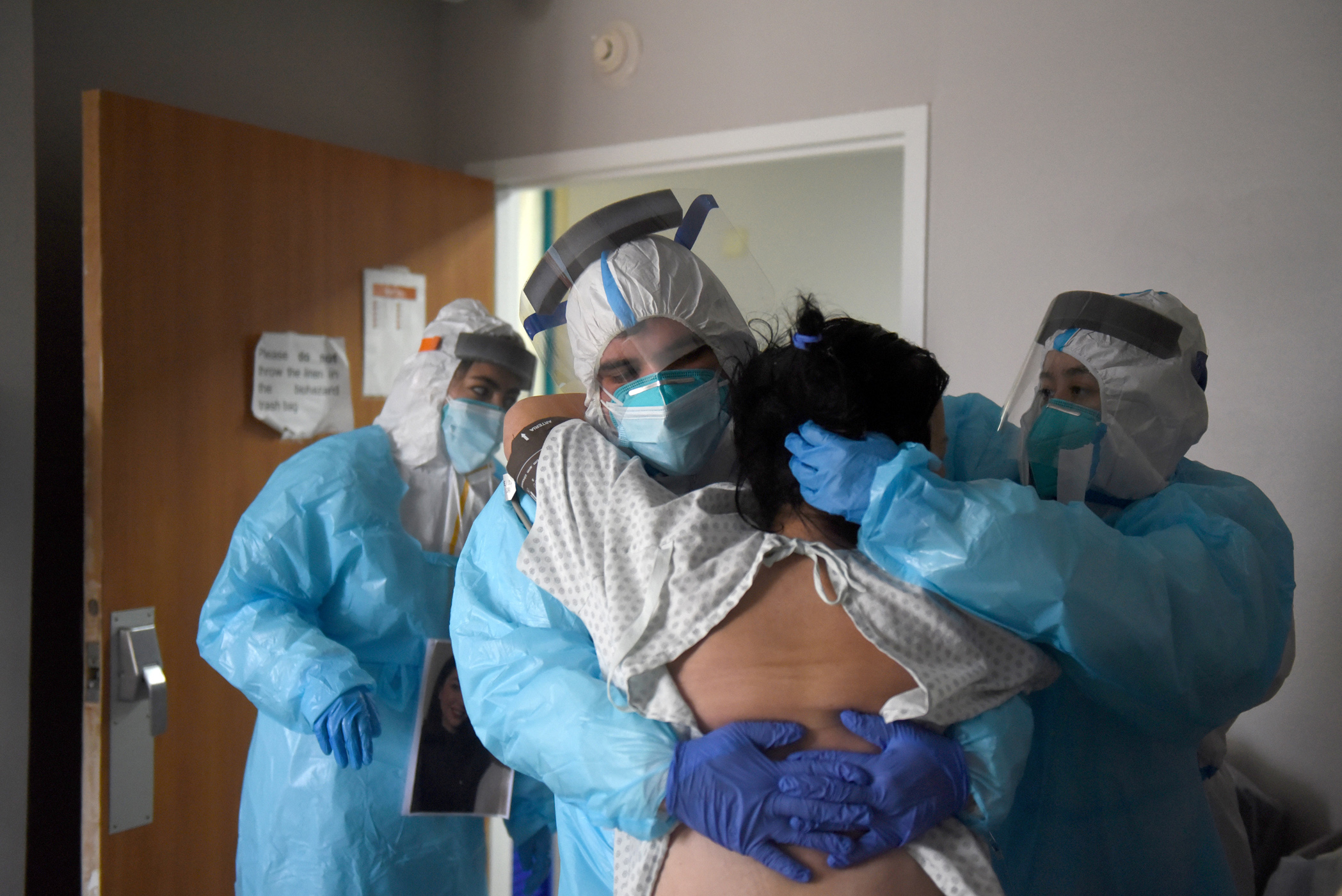 Alonso Lugo helps a patient try to stand inside the coronavirus disease (COVID-19) unit at United Memorial Medical Center in Houston, Texas, U.S., December 30, 2020.  REUTERS