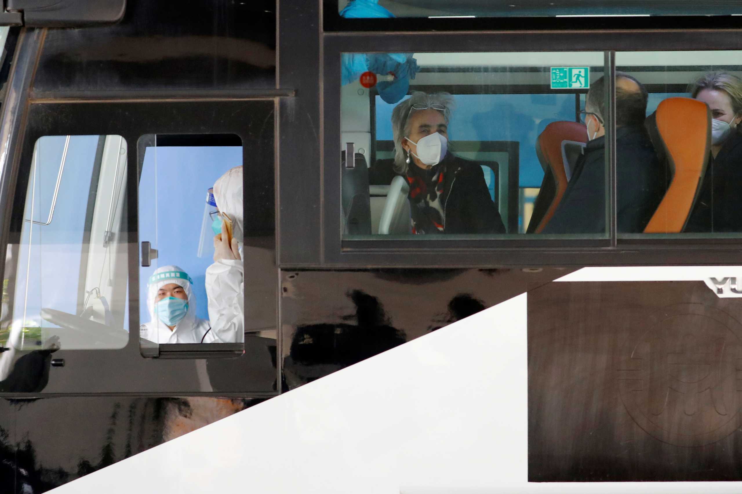 Members of the World Health Organisation (WHO) team tasked with investigating the origins of the coronavirus disease (COVID-19) pandemic sit on a bus before leaving Wuhan Tianhe International Airport in Wuhan, Hubei province, China January 14, 2021. REUTERS
