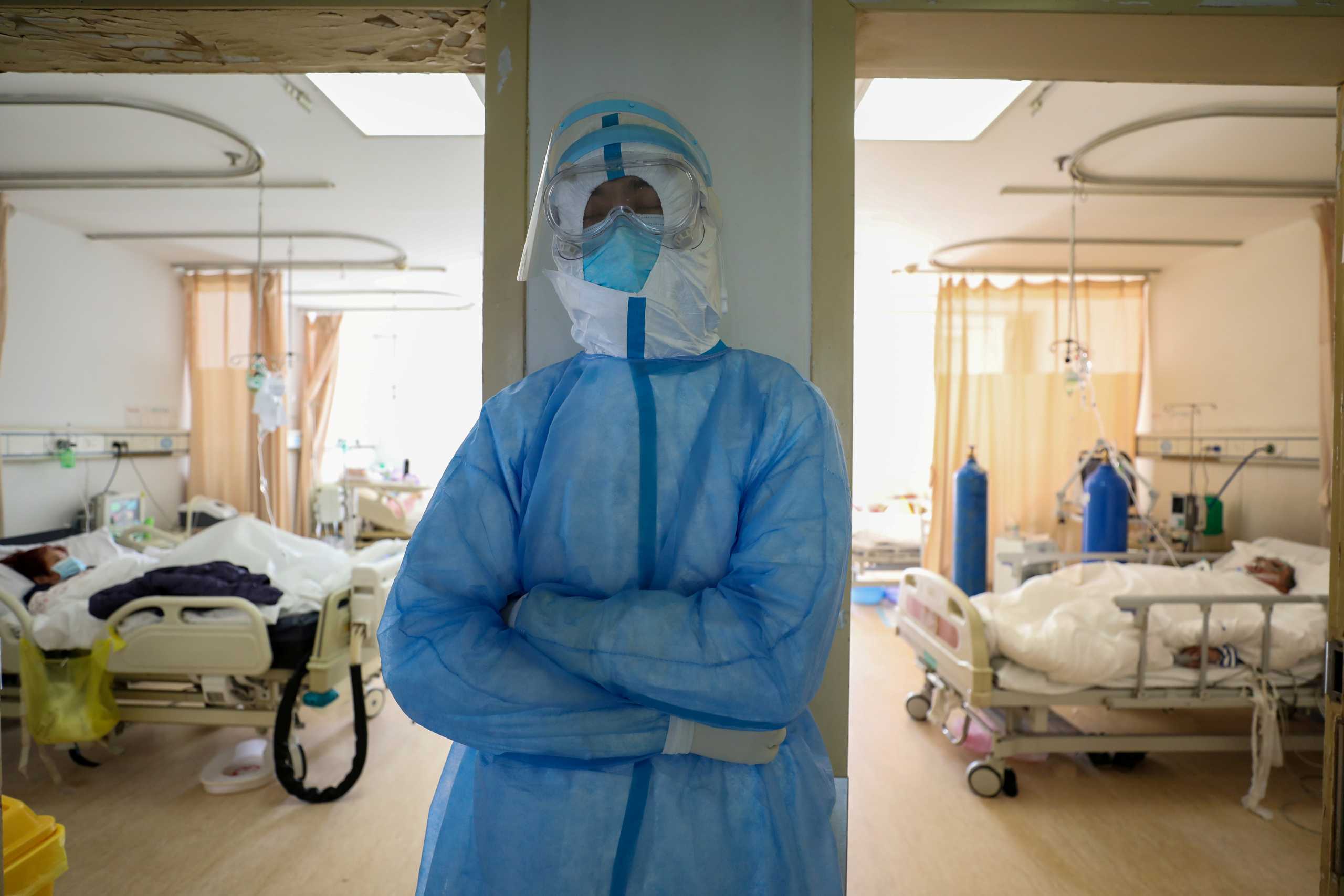 FILE PHOTO: A medical worker in protective suit takes a break at an isolated ward of Wuhan Red Cross Hospital in Wuhan, the epicentre of the novel coronavirus outbreak, in Hubei province, China February 16, 2020. China Daily via REUTERS