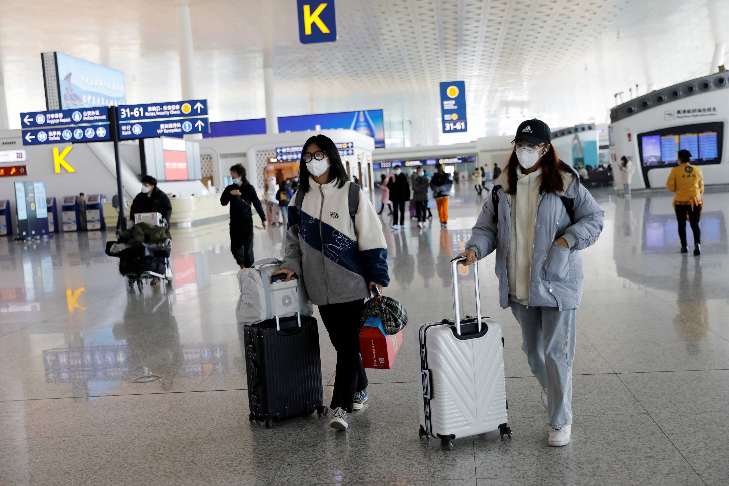 Travellers walk with their luggage at Wuhan Tianhe International Airport following the coronavirus disease (COVID-19) outbreak in Wuhan, Hubei province, China January 2, 2021. REUTERS