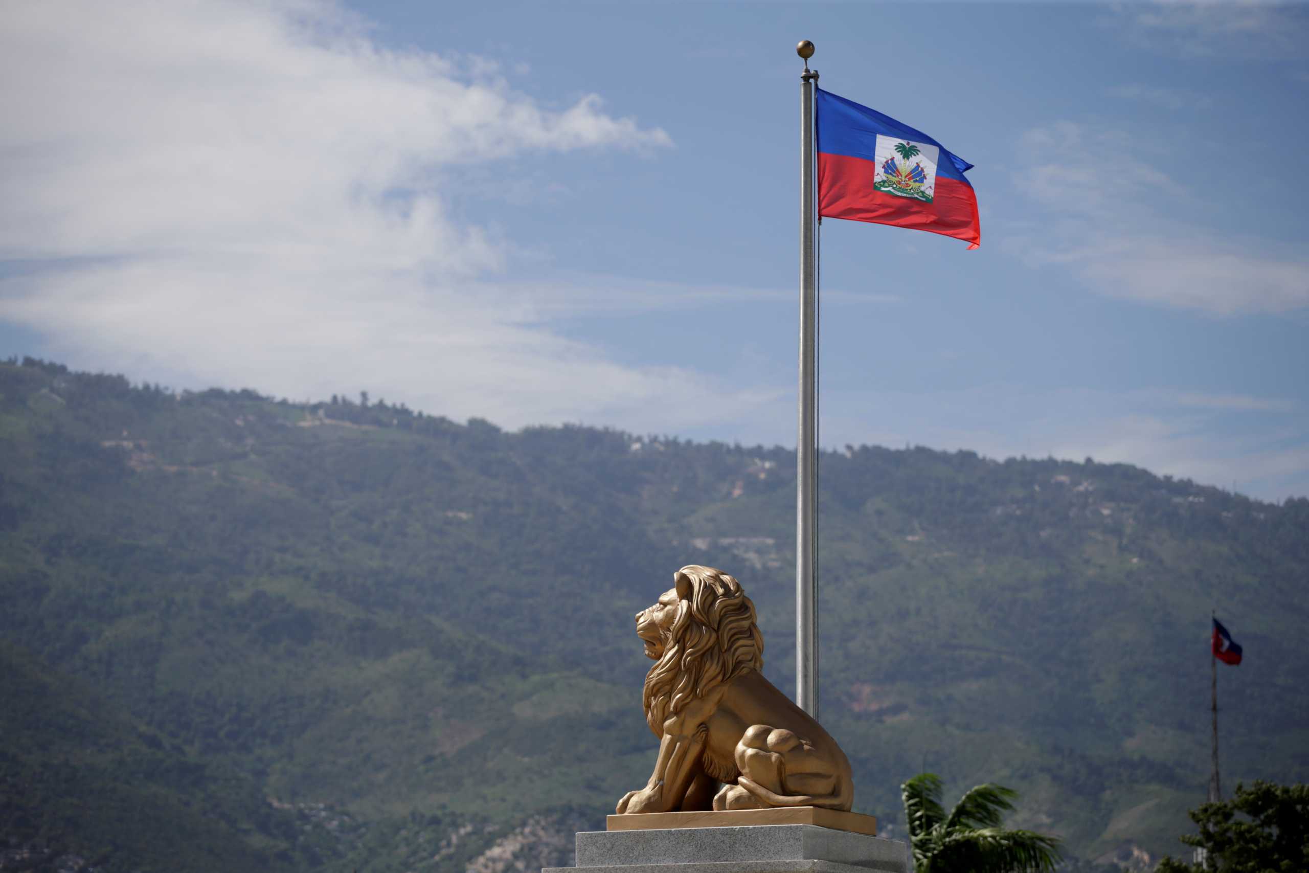 FILE PHOTO: The Haitian flag is seen next to the statue of a lion at the Court of Cassation (Supreme Court) in Port-au-Prince, Haiti October 5, 2020. REUTERS