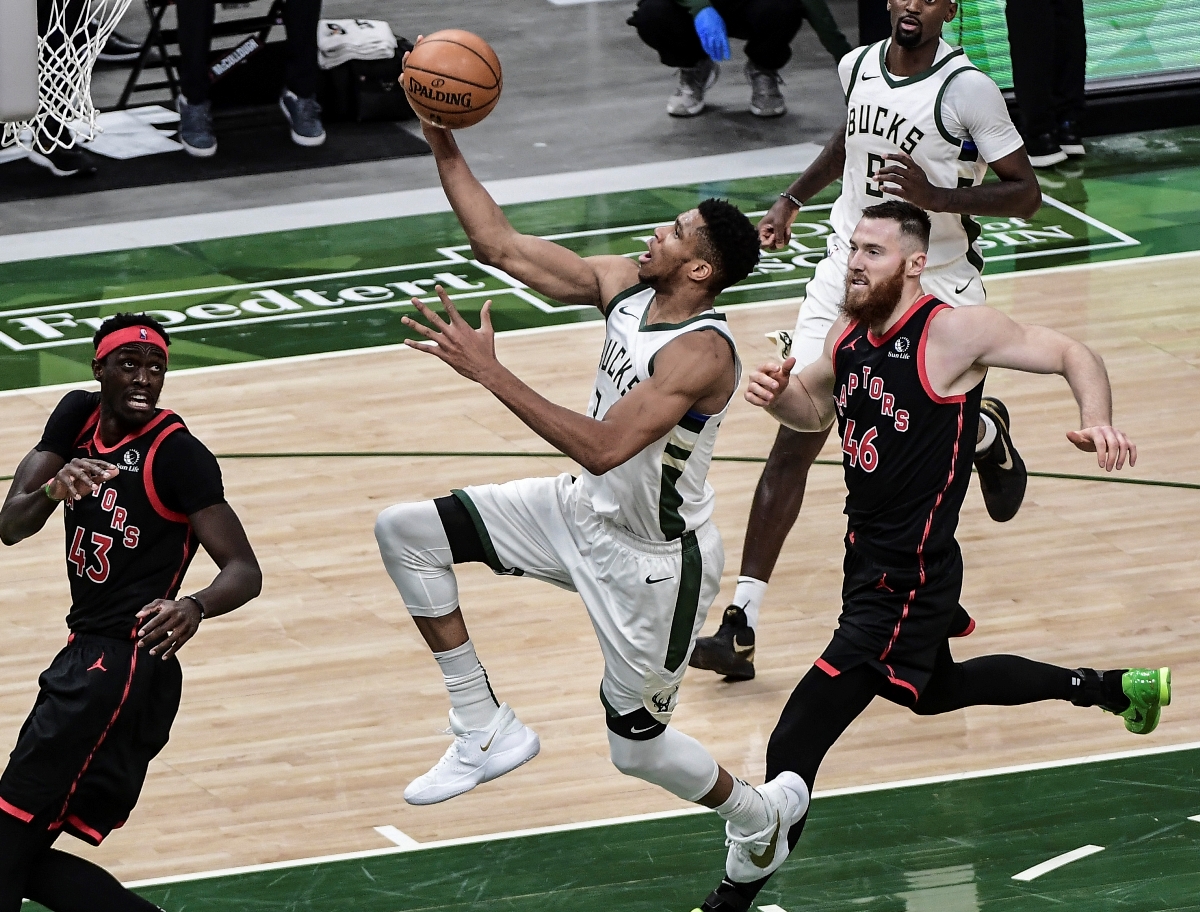 Feb 16, 2021; Milwaukee, Wisconsin, USA; Milwaukee Bucks forward Giannis Antetokounmpo (34) takes a shot against Toronto Raptors center Aron Baynes (46) and forward Pascal Siakam (43) in the fourth quarter at Fiserv Forum. Mandatory Credit: Benny Sieu-USA TODAY Sports