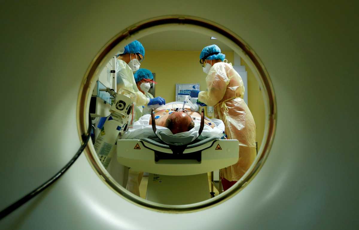 FILE PHOTO: Members of the medical staff in protective suits treat a patient suffering from the coronavirus disease (COVID-19) with a computer tomograph in the Intensive Care Unit (ICU) at Havelhoehe community hospital in Berlin, Germany, October 30, 2020. REUTERS