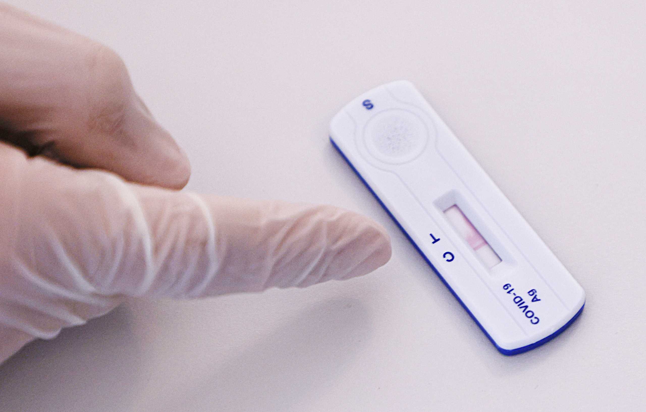 A health care worker in protective equipment points to a quick COVID-19 test in a rapid antigen mass testing station, as the spread of the coronavirus disease (COVID-19) continues, in Vienna, Austria, February 3, 2021.   REUTERS
