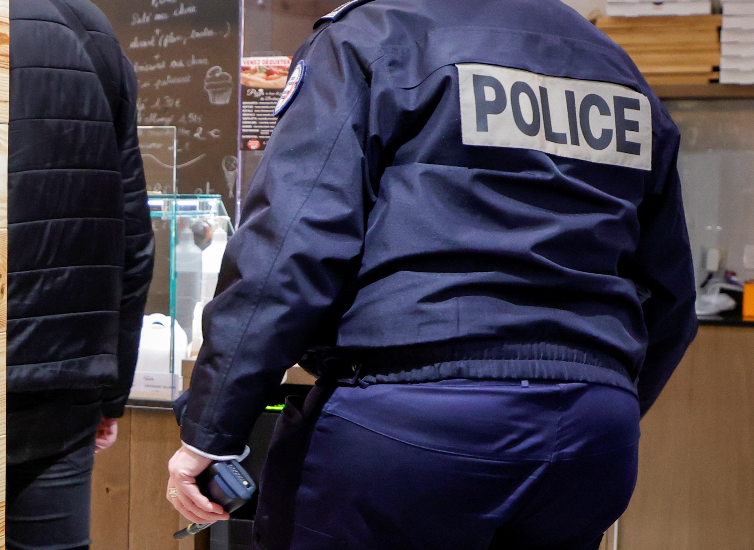 French police officers inspect a bakery during a nationwide curfew, from 6 p.m to 6 a.m, due to tighter measures against the spread of the coronavirus disease (COVID-19), in Paris, France February 5, 2021. REUTERS