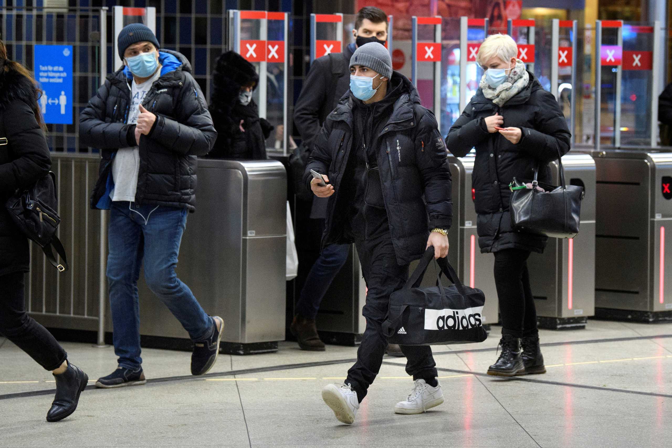 FILE PHOTO: Passengers wearing protective masks enter an underground railway station, amid the spread of the coronavirus disease (COVID-19) pandemic, in Stockholm, Sweden, January 7, 2021. Jessica Gow