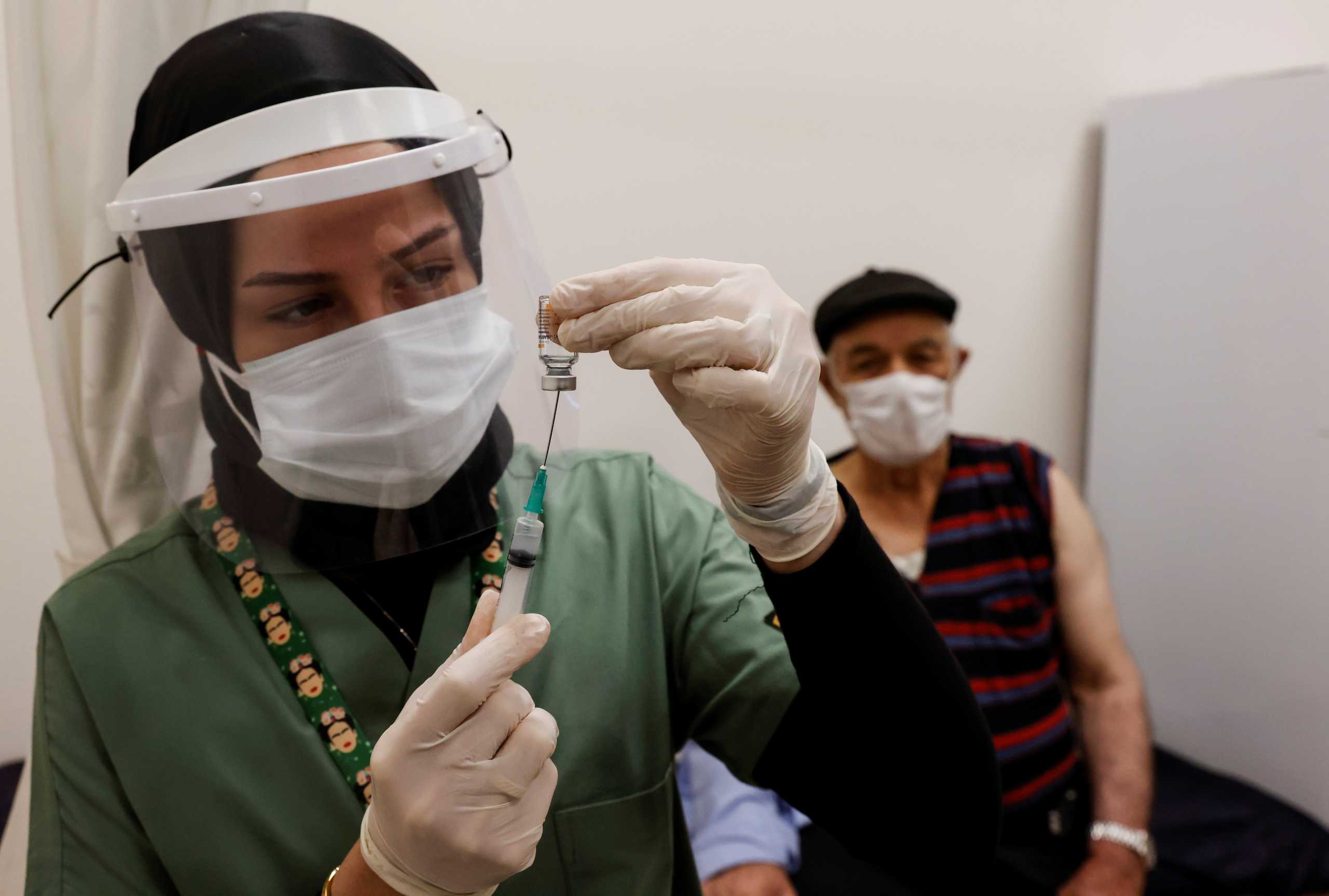 Nurse Fatma Sahin prepares a shot of the Sinovac's CoronaVac COVID-19 vaccine for Sevki Akbulut as nationwide vaccination began for seniors of 80 years old or older at Sancaktepe Education and Research Hospital, in Istanbul, Turkey, January 27, 2021. REUTERS