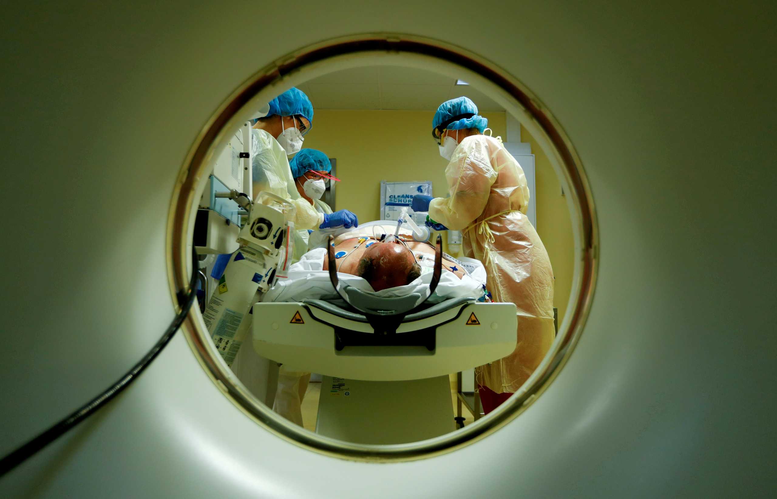 FILE PHOTO: Members of the medical staff in protective suits treat a patient suffering from the coronavirus disease (COVID-19) with a computer tomograph in the Intensive Care Unit (ICU) at Havelhoehe community hospital in Berlin, Germany, October 30, 2020. REUTERS