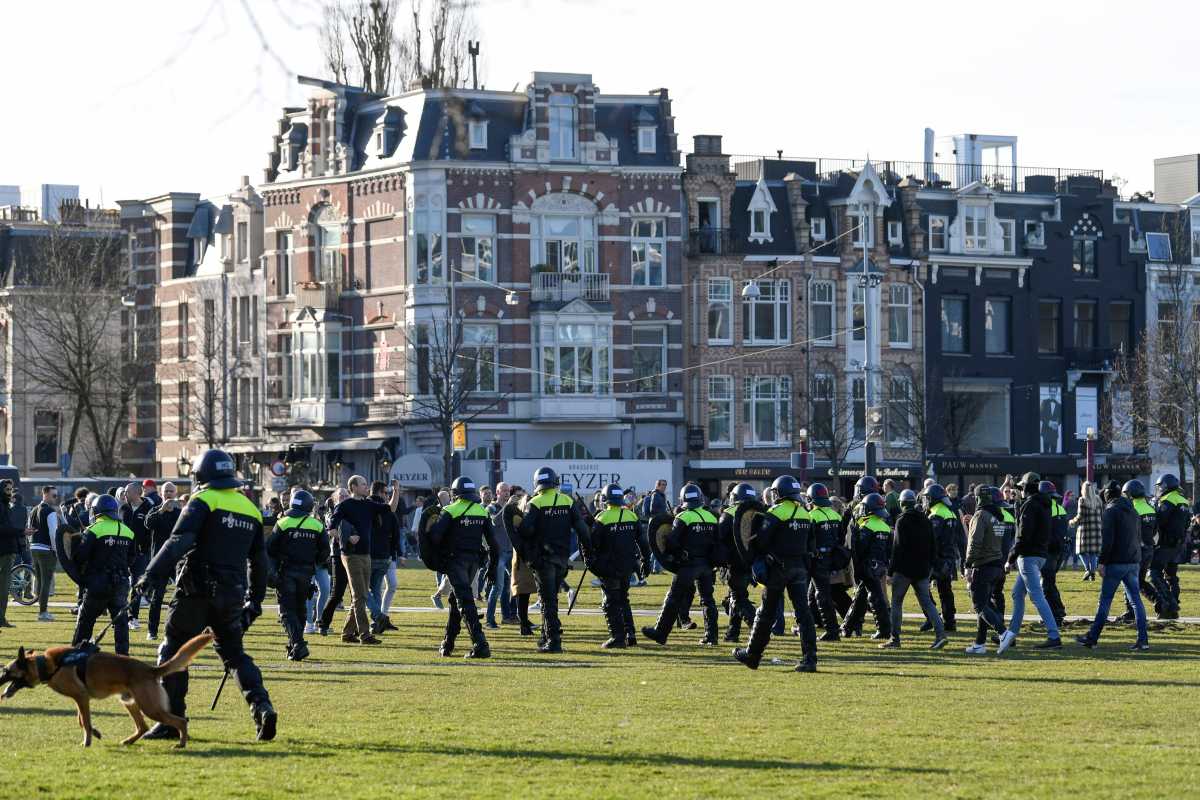 FILE PHOTO: Police officers are seen, as people protest against the coronavirus disease (COVID-19) restrictions in Amsterdam, Netherlands, February 21, 2021. REUTERS