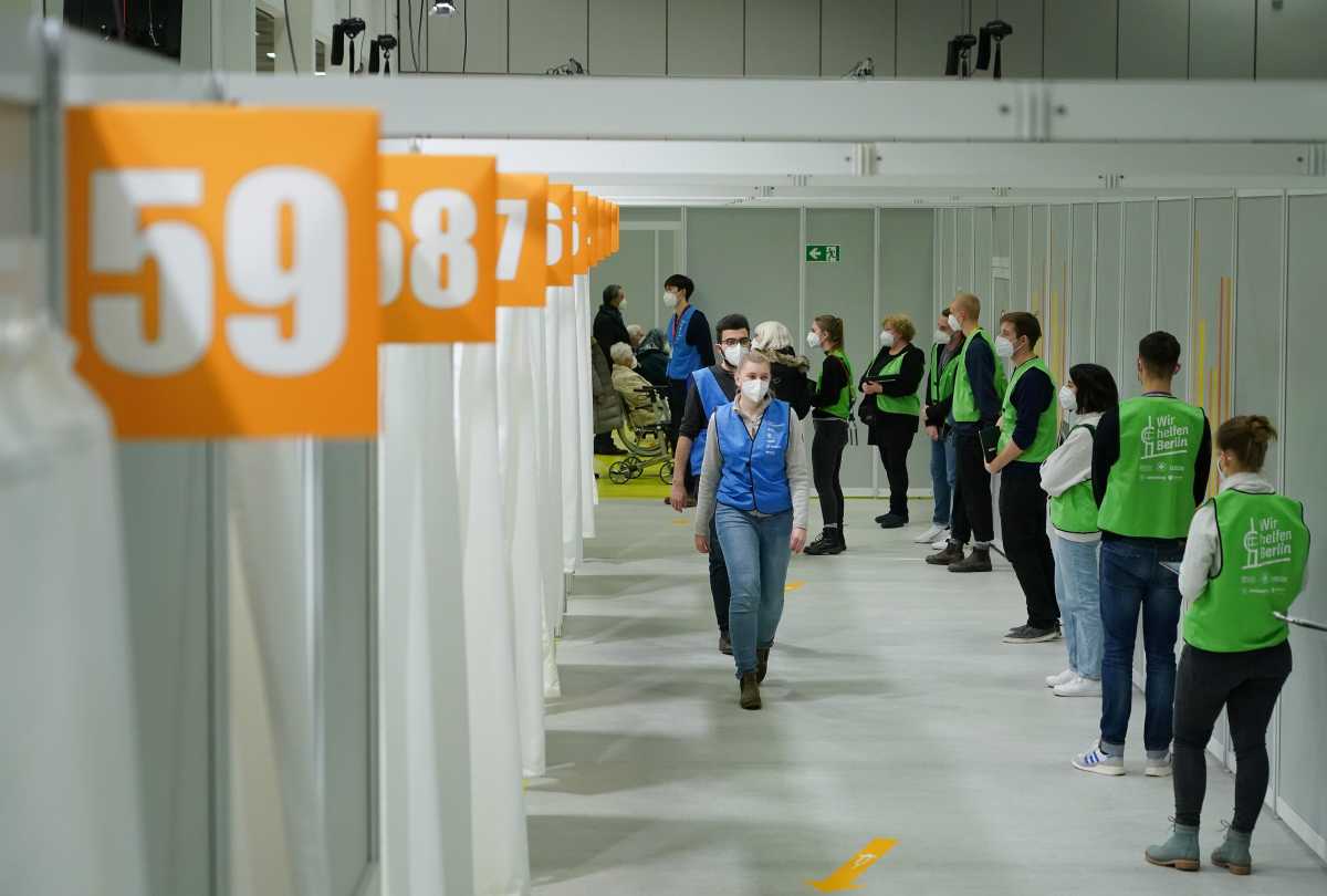 Vaccine center workers stand near cabins being used to inoculate people against the coronavirus disease (COVID-19) on the opening day of a vaccination center at the Messe Berlin trade fair grounds in Berlin, Germany January 18, 2021. Sean Gallup