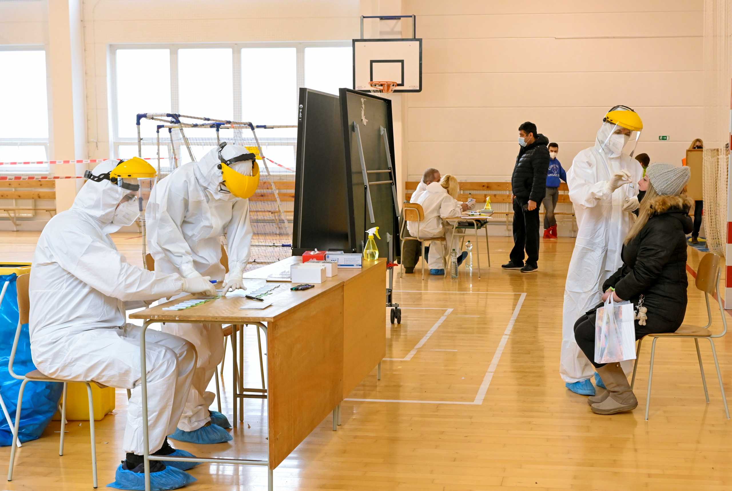 Polish healthcare workers (L) help during a mass nationwide testing for coronavirus disease (COVID-19) in Zilina, Slovakia, January 23, 2021. REUTERS
