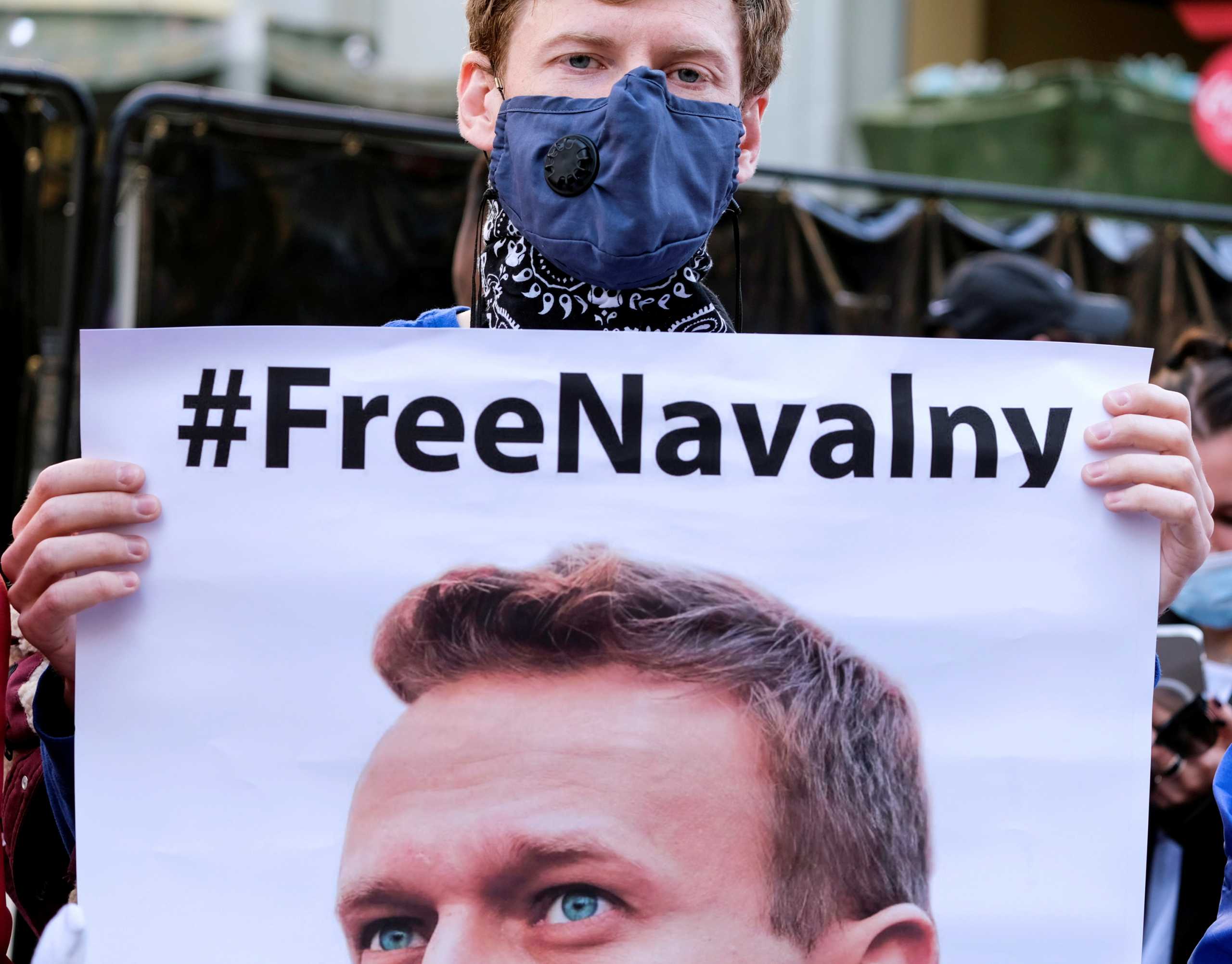 FILE PHOTO: A protester wearing a face mask holds a poster of Alexei Navalny in Hollywood during a demonstration in support of Russian opposition leader Alexei Navalny, who was sentenced to jail, in Los Angeles, California, U.S. February 6, 2021.  REUTERS