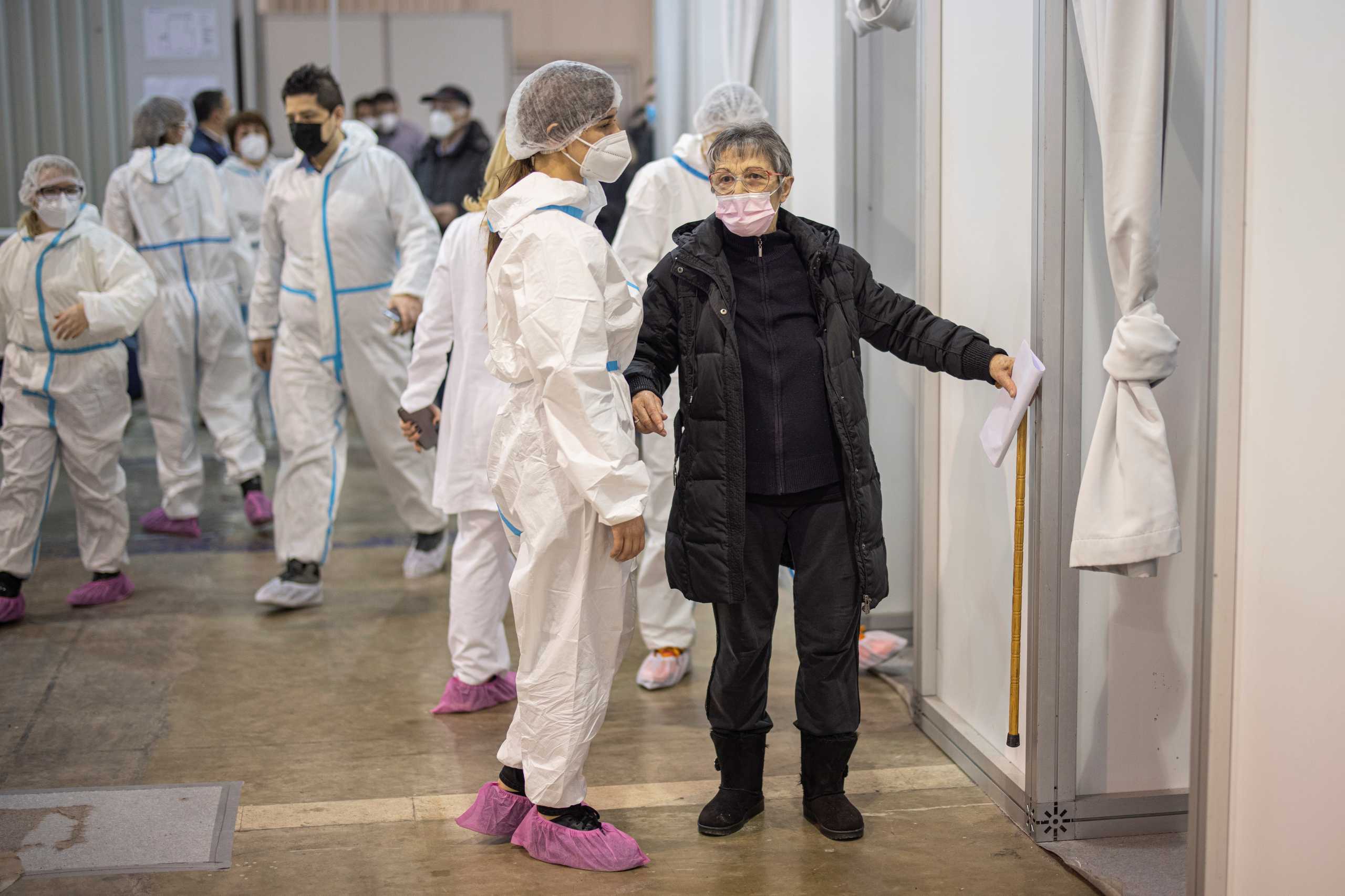 A medical assists helps a woman who is to receive a dose of the Pfizer-BioNTech COVID-19 vaccine as the country begins mass vaccination for the coronavirus disease (COVID-19), in Belgrade, Serbia, February 3, 2021. REUTERS