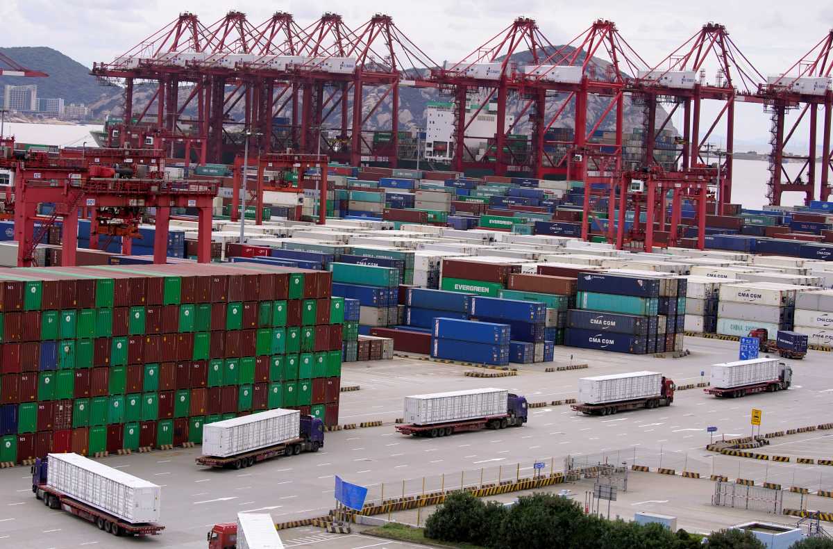 FILE PHOTO: Containers and lorries are seen at the Yangshan Deep Water Port in Shanghai, China, as the coronavirus disease (COVID-19) outbreak continues, October 19, 2020. REUTERS