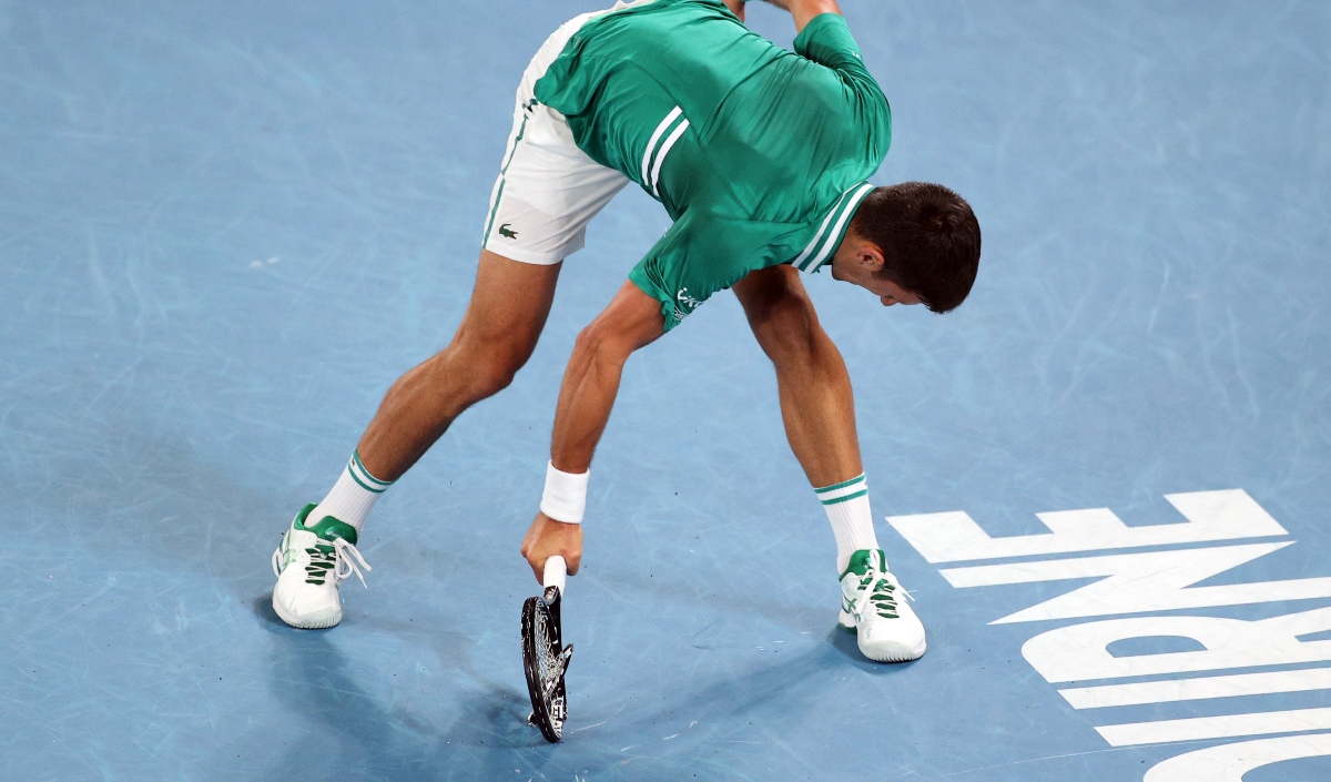 Tennis - Australian Open - Melbourne Park, Melbourne, Australia, February 16, 2021 Serbia's Novak Djokovic reacts as he smashes his racquet on court during his quarter final match against Germany's Alexander Zverev REUTERS