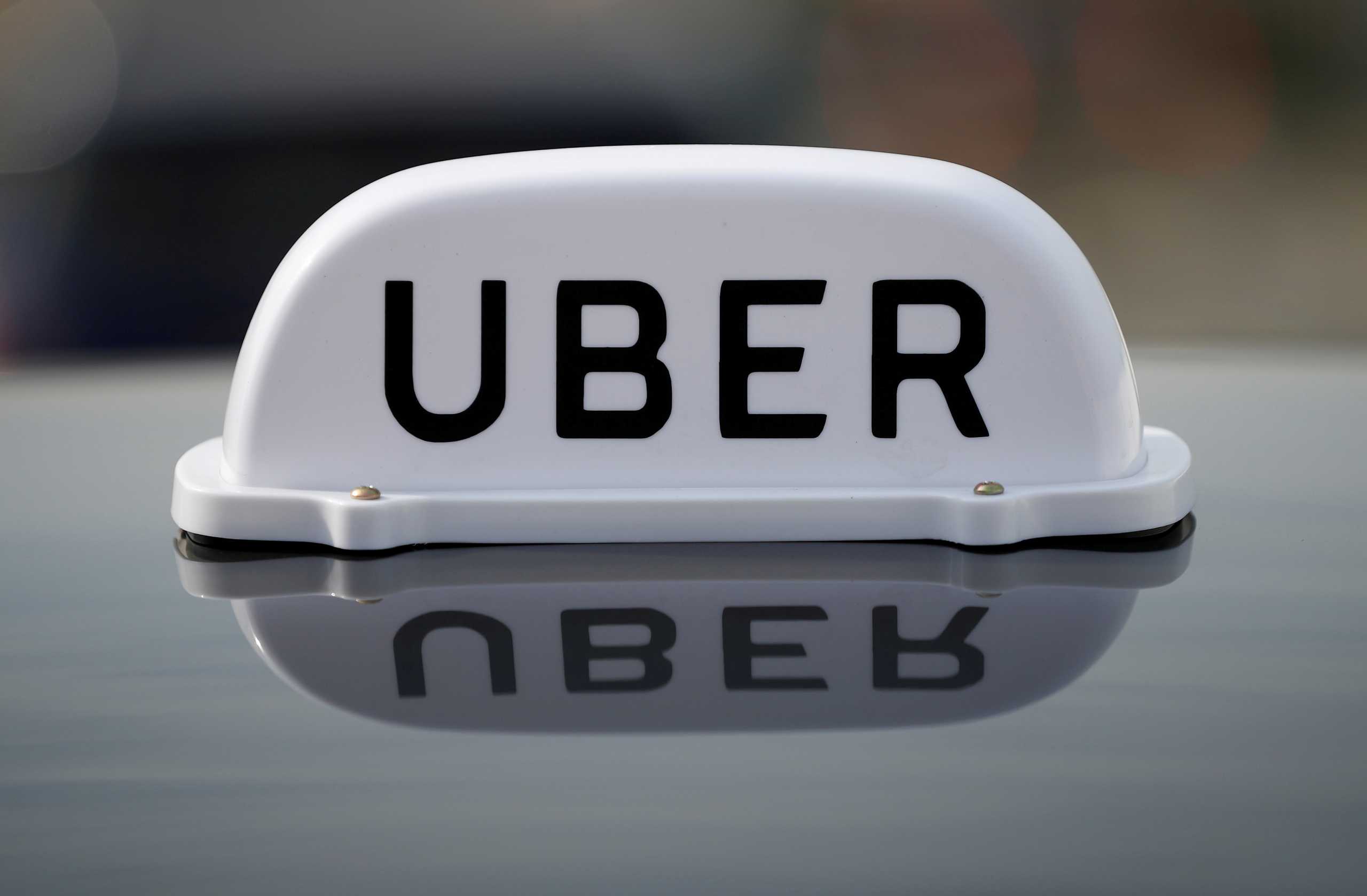 FILE PHOTO: The Logo of taxi company Uber is seen on the roof of a private hire taxi in Liverpool, Britain, April 15, 2019. REUTERS