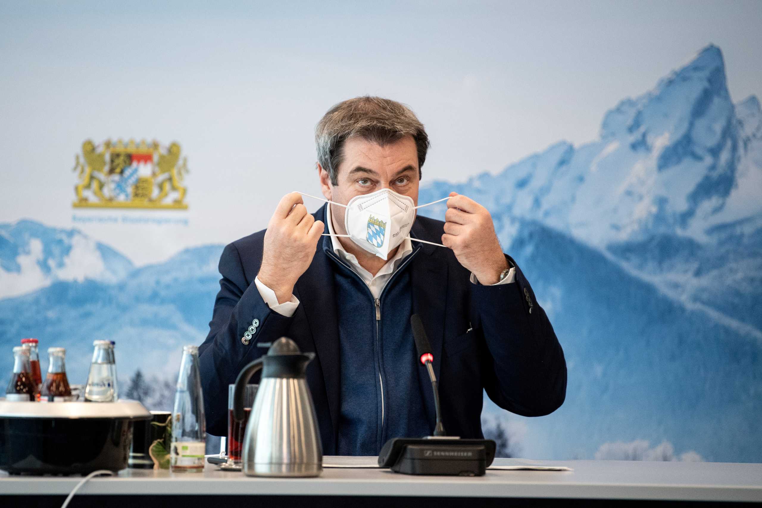 FILE PHOTO: Bavaria's State Prime Minister Markus Soeder removes his protective mask before a so-called home office summit during the coronavirus disease (COVID-19) pandemic in Munich, Germany, January 13, 2021.  Matthias Balk