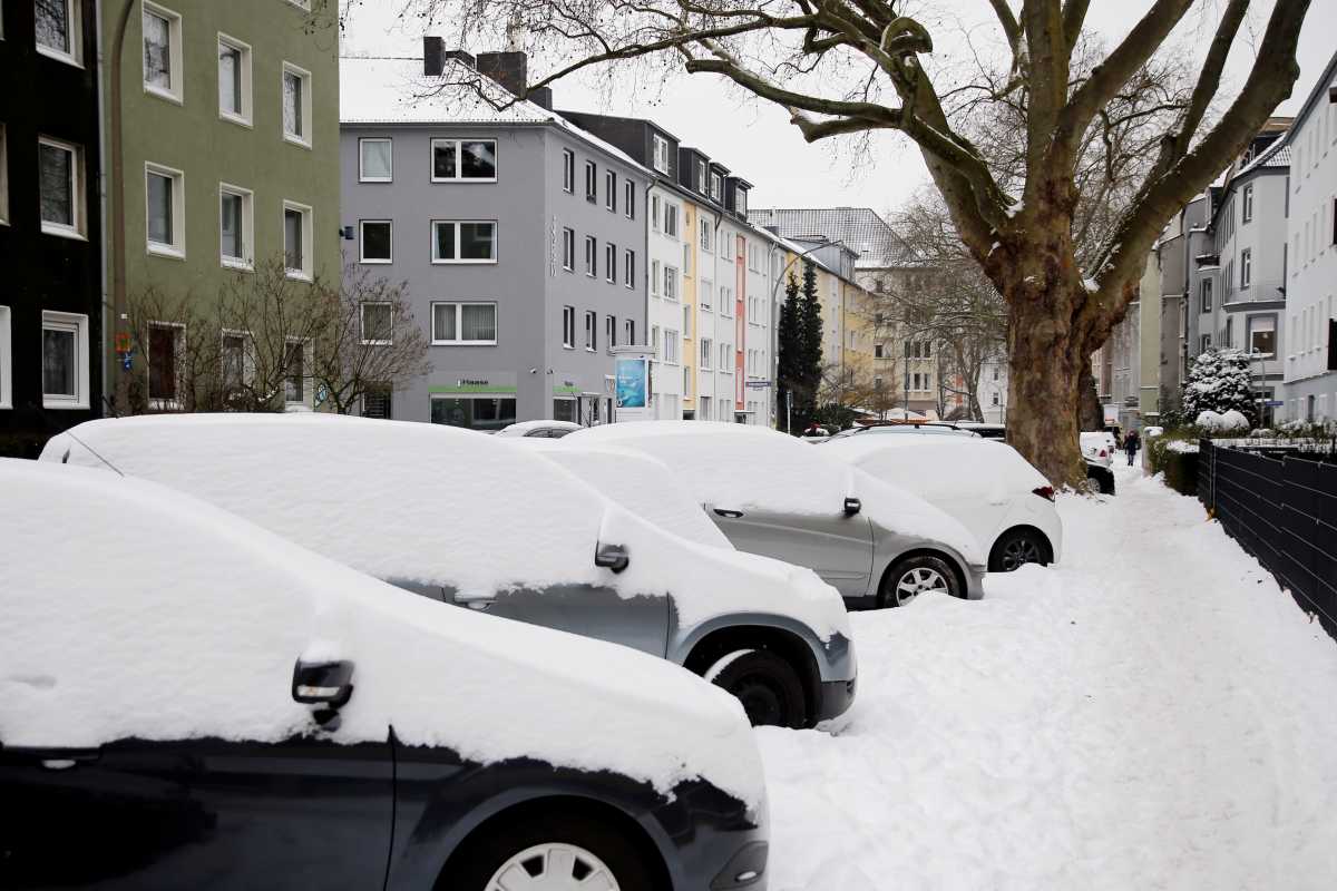 Snow-covered cars are parked during a snowfall in Dortmund, Germany, February 10, 2021. REUTERS