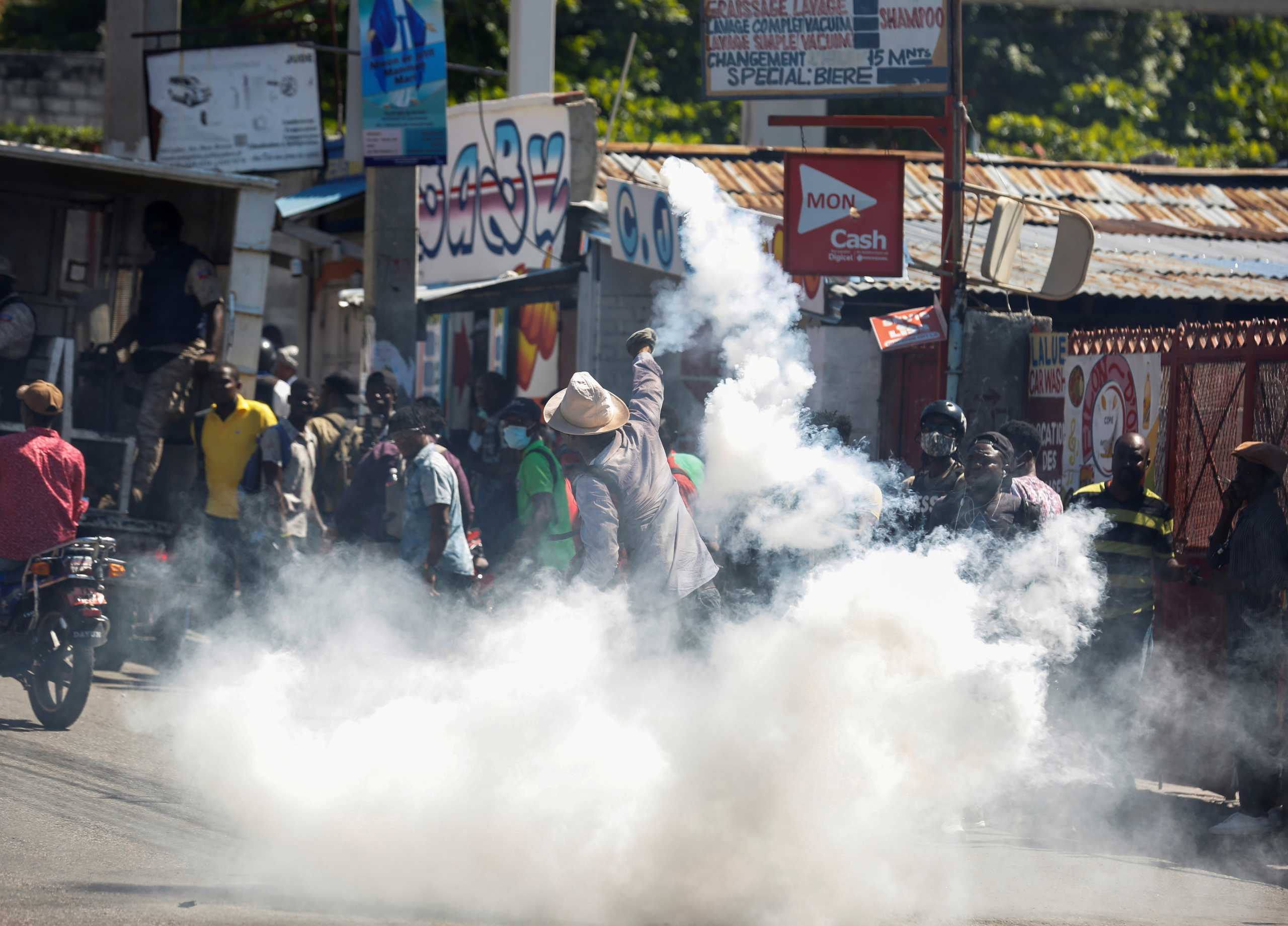 A man throws a tear gas canister back at the police during a protest against Haiti's President Jovenel Moise, in Port-au-Prince, Haiti February 10, 2021.  REUTERS
