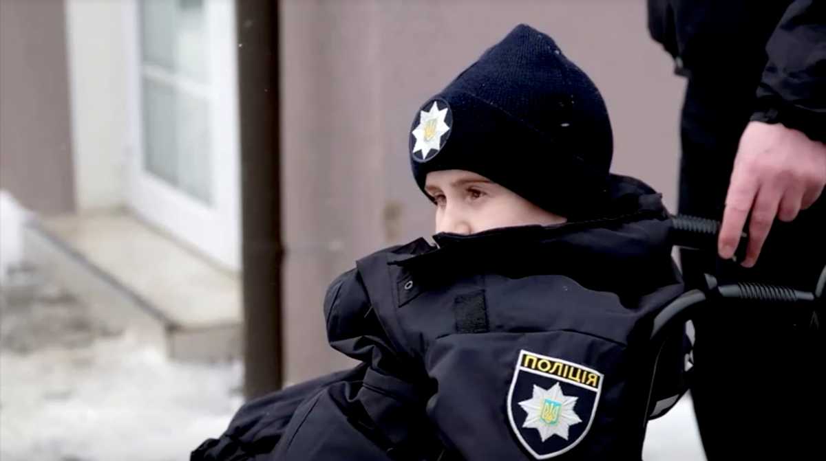 A still image taken from video footage shows Oleksandr Andriychuk, who is terminally ill with brain cancer, during a ceremony organized by police in the town of Chernivtsi, Ukraine February 15, 2021. The chance to become a police officer was a dream come true for 10-year-old Oleksandr, who enrolled in his local police force during a special ceremony in front of his home and spent a day on patrol. Video taken February 15, 2021. SHPALTA.MEDIA