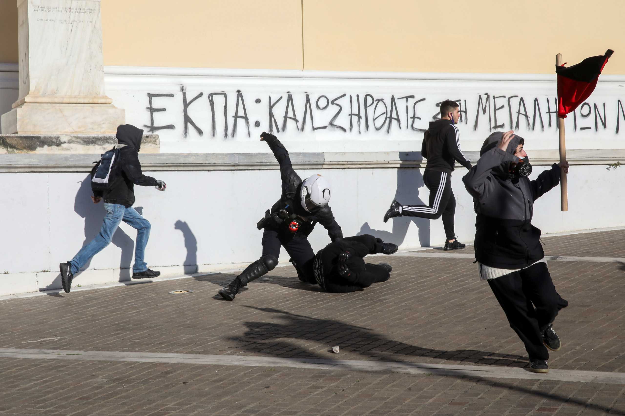 A police officer detains a protester as Greek university students demonstrate against government plans to set up university police, amid the coronavirus disease (COVID-19) pandemic, in Athens, Greece, February 10, 2021. REUTERS