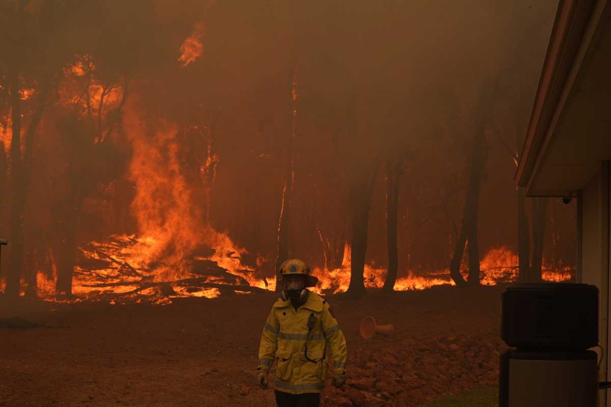 A Department of Fire and Emergency Services fire fighter battles a bushfire in Brigadoon, Perth, Australia, February 2, 2021.   AAP Image