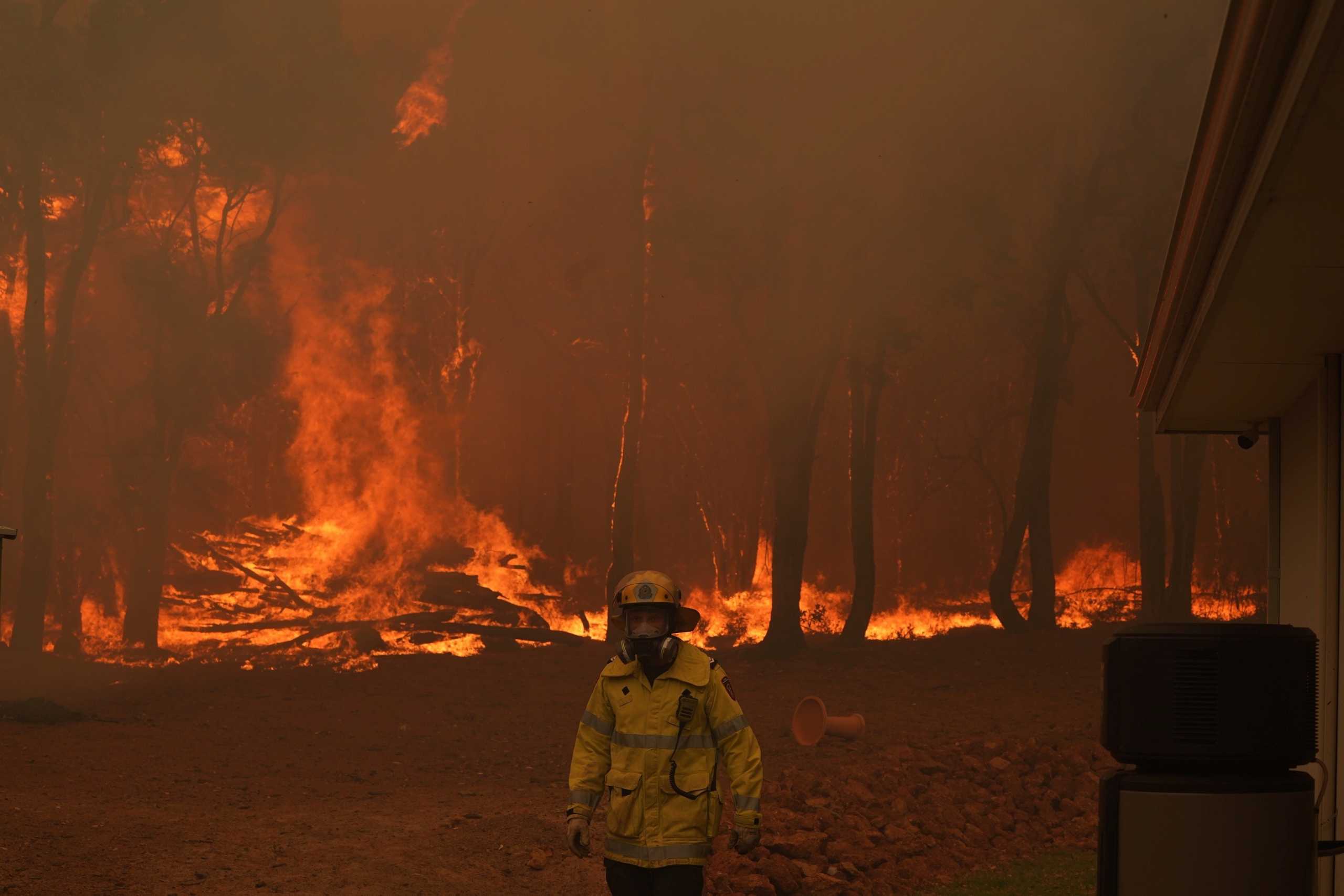 A Department of Fire and Emergency Services fire fighter battles a bushfire in Brigadoon, Perth, Australia, February 2, 2021.   AAP Image