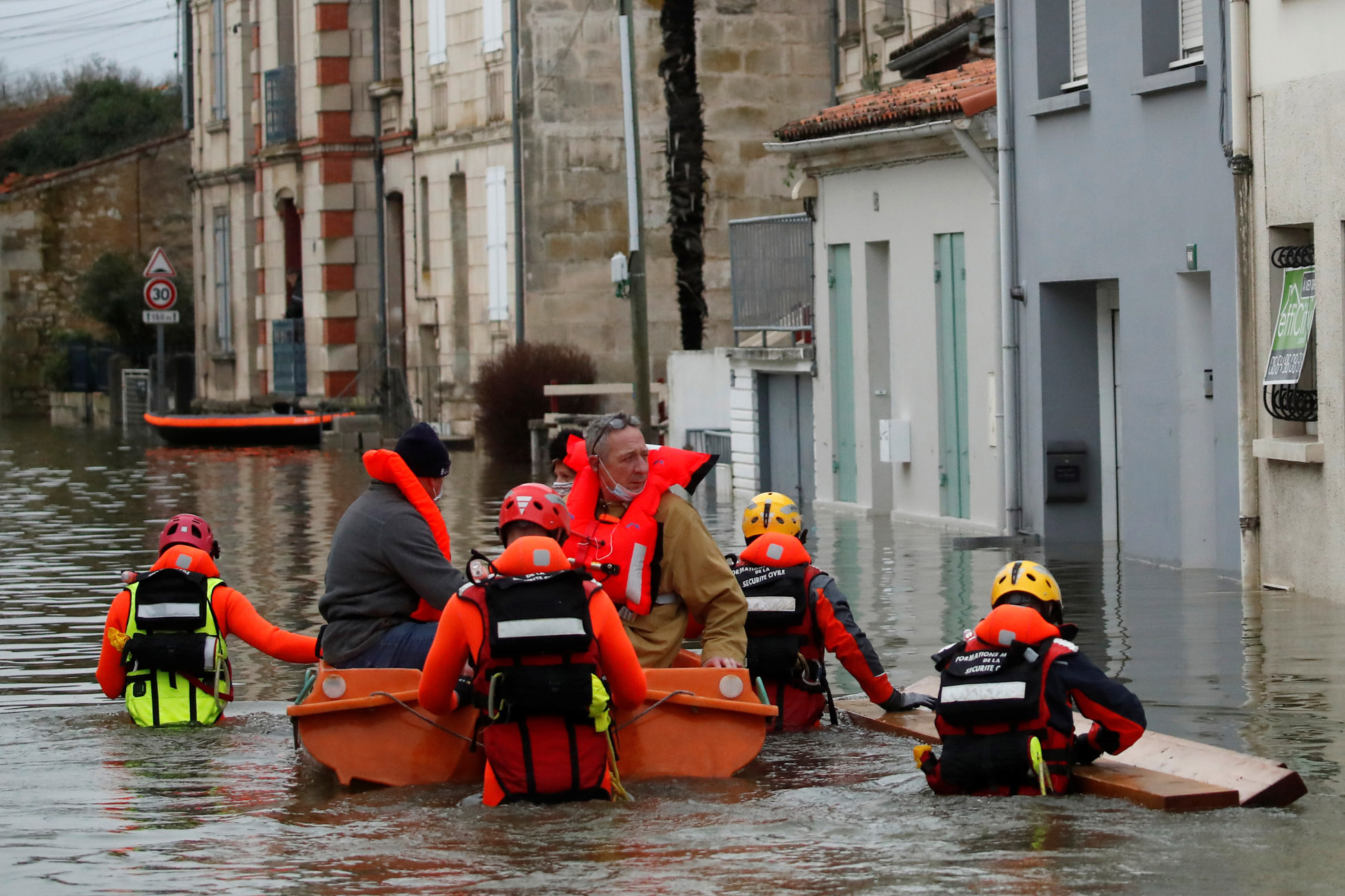 Rescue workers on small boats help residents in a flooded area as the Charente River overflows in Saintes after days of rainy weather causing flooding in western France, France, February 8, 2021. REUTERS