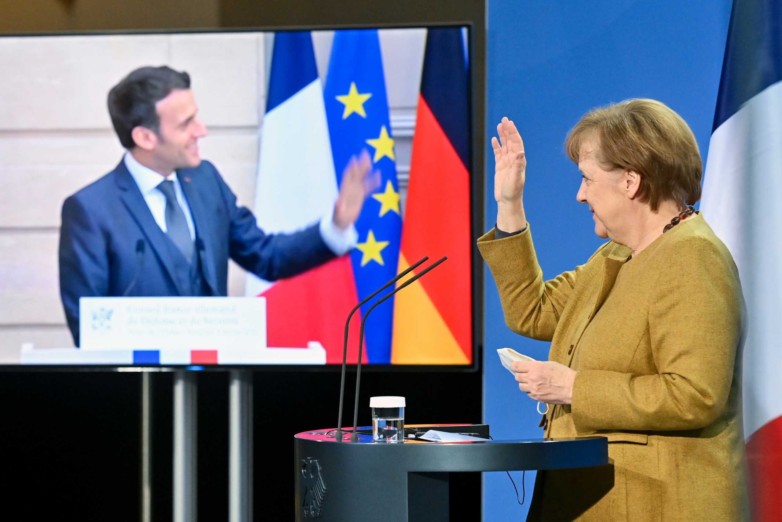 German Chancellor Angela Merkel and French President Emmanuel Macron wave at the end of a press conference after German-French Security Council video talks, in Berlin, Germany February 5, 2021. John Macdougall