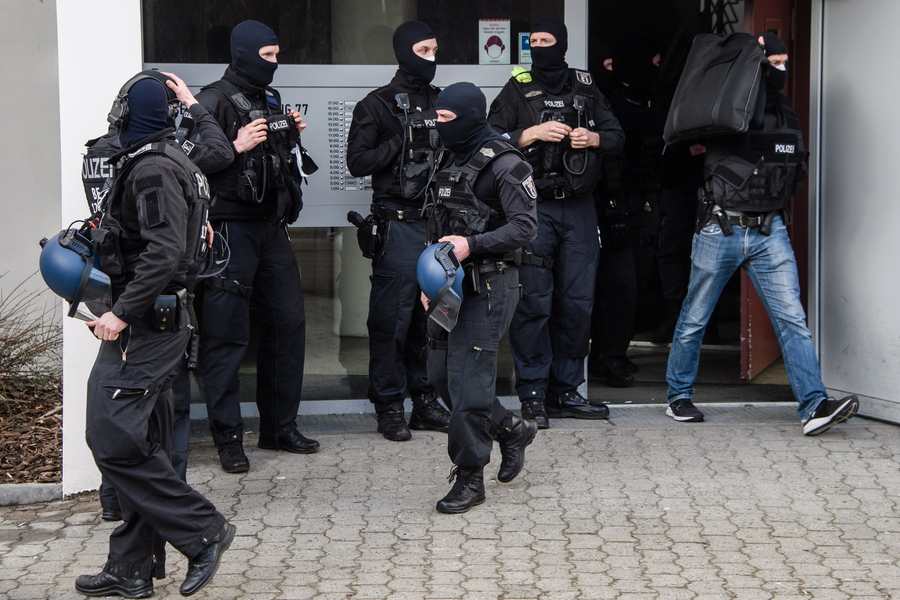 epa09035186 Policemen leave a residential building at Maerkisches Viertel city district during a police operation in Berlin, Germany, 25 February 2021. According to police, police forces from Berlin and Brandenburg undertake a large-scale raid on Islamist supporters since early this morning. The searches are related to the ban of the Jihad-Salafist organisation Jama'atu Berlin alias Tauhid Berlin by the Berlin Senate Department for the Interior and Sport.  EPA