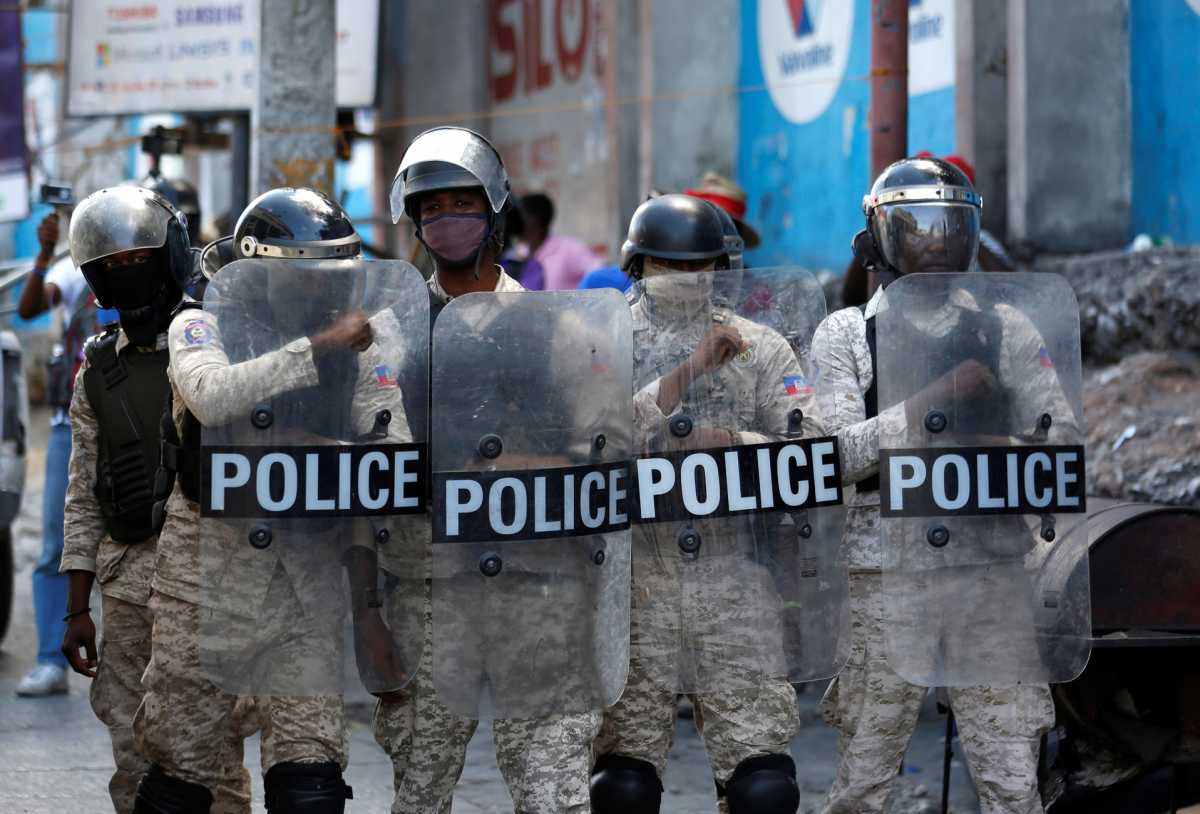Police officers stand guard as demonstrators take part in a protest against Haiti's President Jovenel Moise, in Port-au-Prince, Haiti February 14, 2021. REUTERS