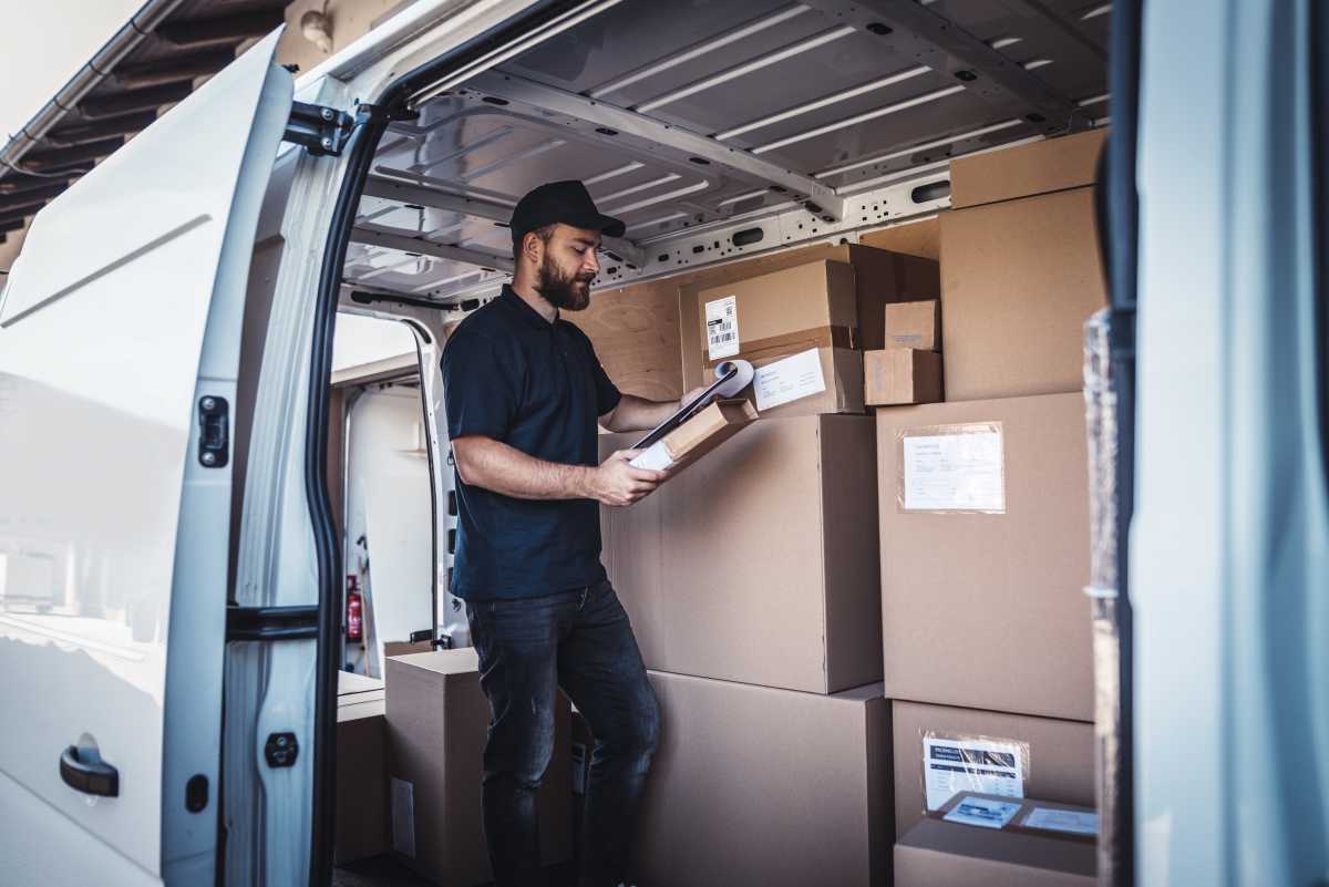 Young man checking a list of packages one more time.