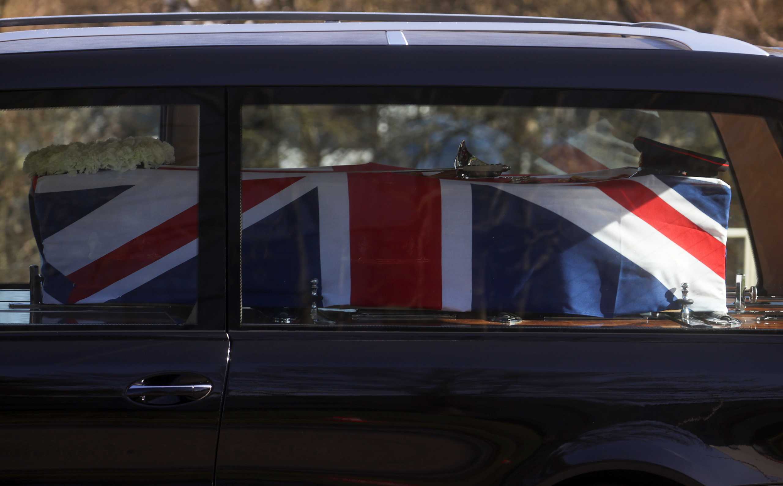 The coffin with the remains of Captain Sir Tom Moore covered with British flag is seen inside a hearse, amid the coronavirus disease (COVID-19) outbreak, in Marston Moretaine, near Milton Keynes, Britain, February 27, 2021. REUTERS