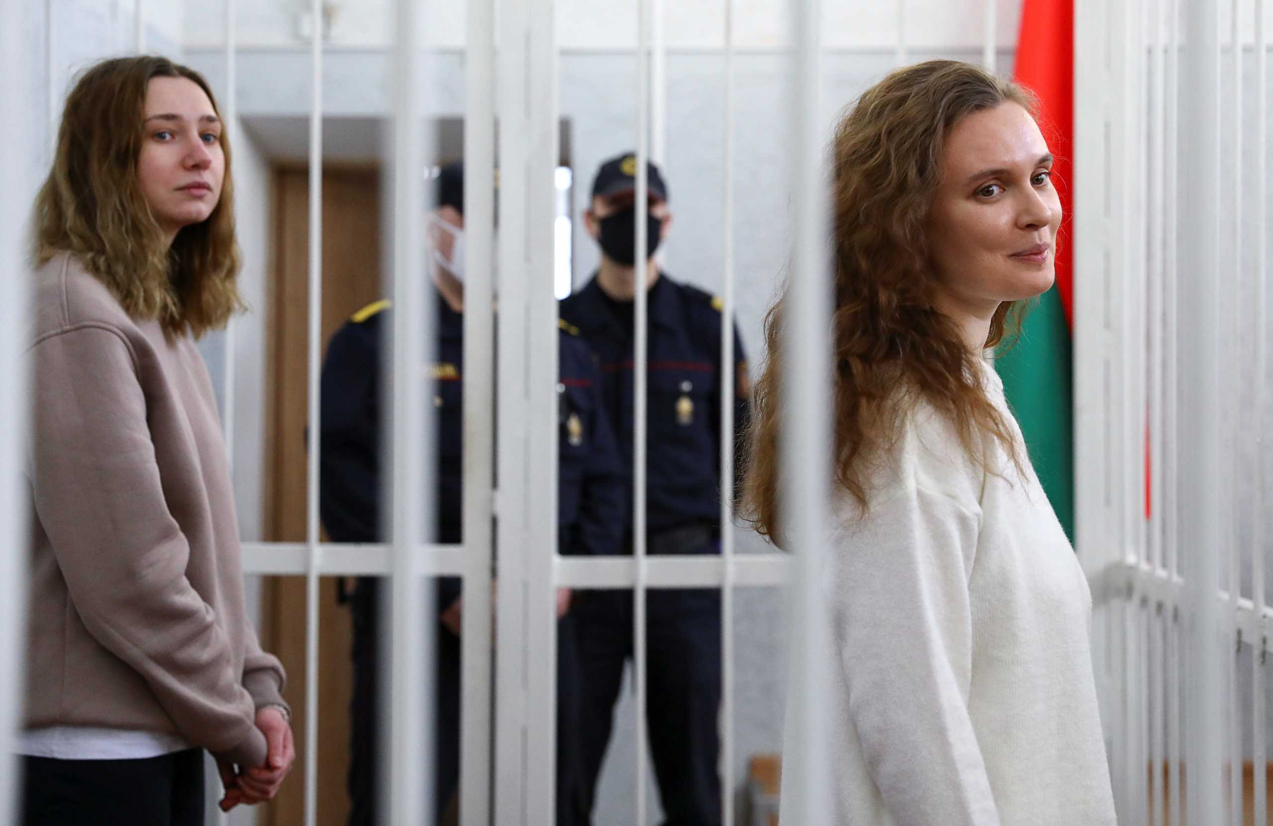 Katsiaryna Andreyeva and Darya Chultsova, Belarusian journalists working for the Polish television channel Belsat accused of coordinating mass protests in 2020 by broadcasting live reports, stand inside a defendants' cage during a court hearing in Minsk, Belarus February 18, 2021. REUTERS