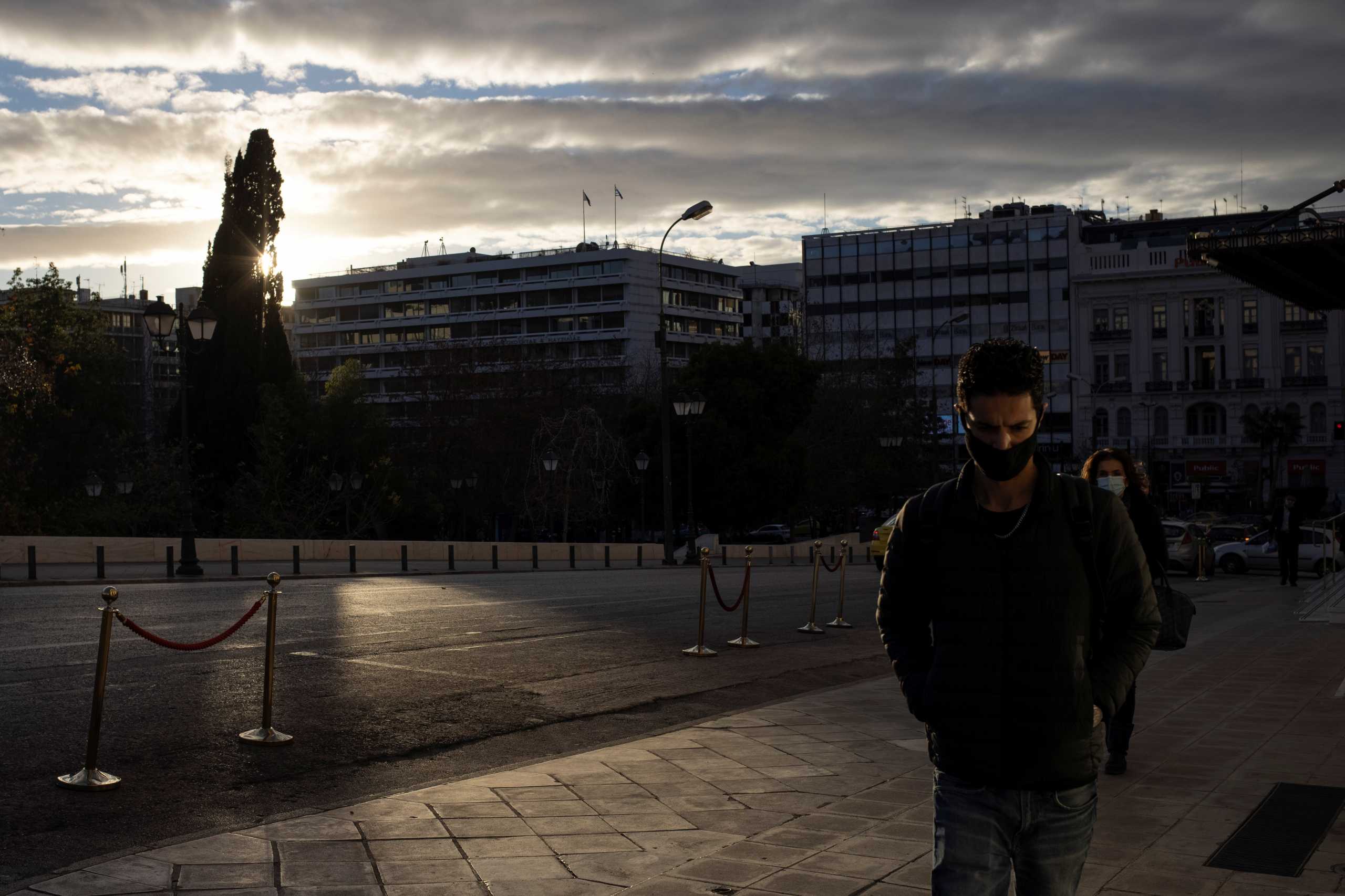 People wearing protective face masks make their way at Syntagma square, amid the coronavirus disease (COVID-19) pandemic, in Athens, Greece January 14, 2021. REUTERS