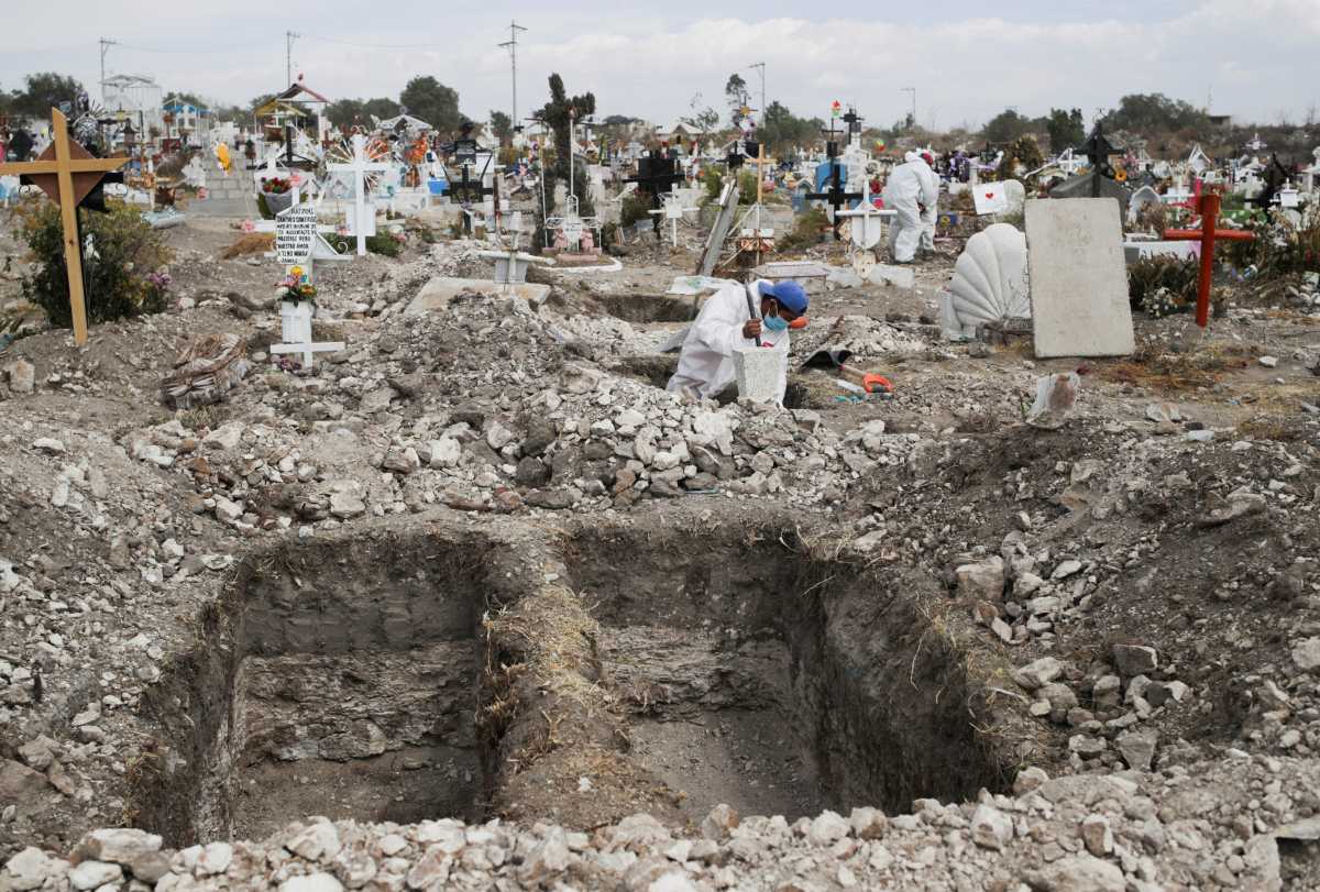 A cemetery worker wearing a protective suit digs new graves at the San Isidro Municipal cemetery, as the outbreak of the coronavirus disease (COVID-19) continues, in Ecatepec de Morelos, on the outskirts of Mexico City, Mexico February 11, 2021. REUTERS