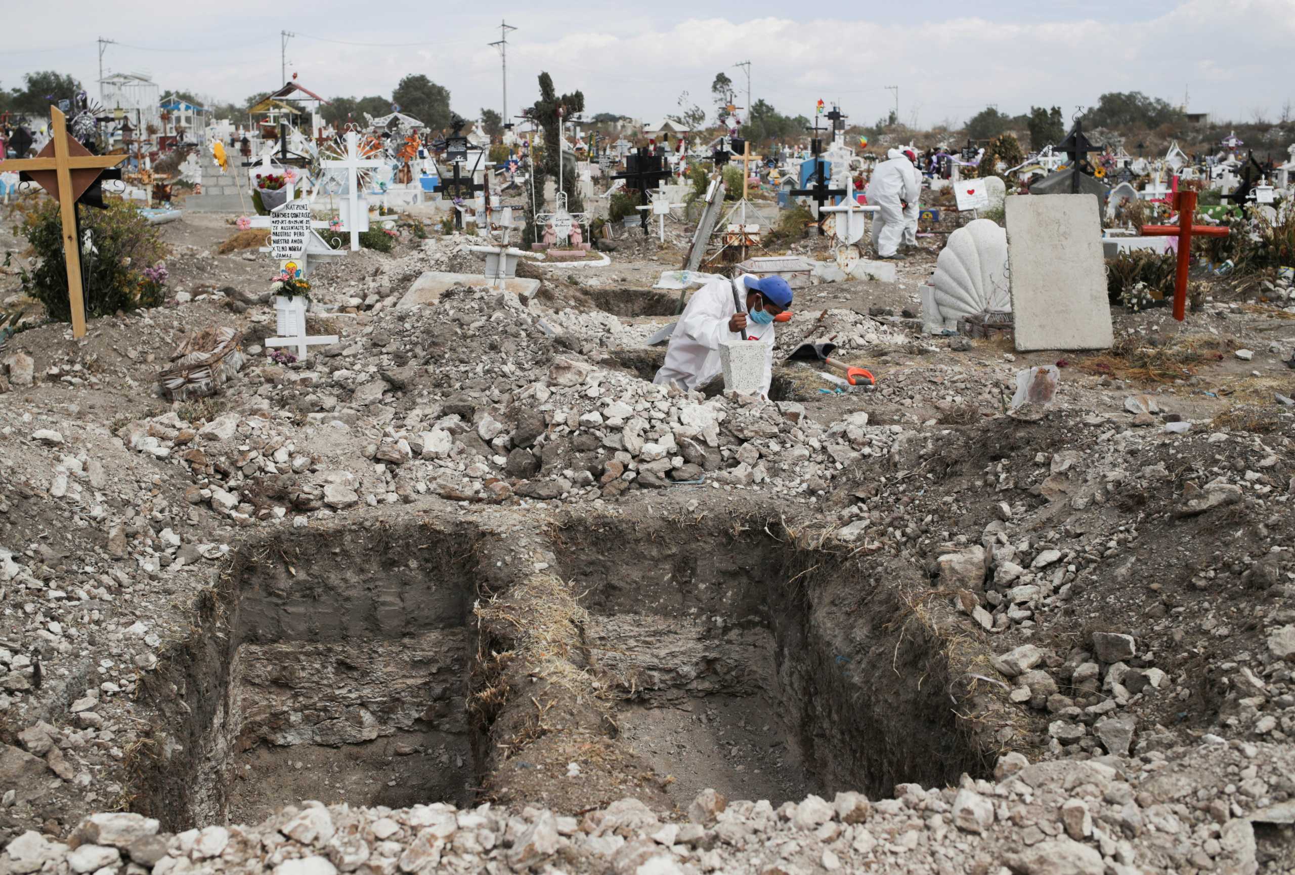 A cemetery worker wearing a protective suit digs new graves at the San Isidro Municipal cemetery, as the outbreak of the coronavirus disease (COVID-19) continues, in Ecatepec de Morelos, on the outskirts of Mexico City, Mexico February 11, 2021. REUTERS