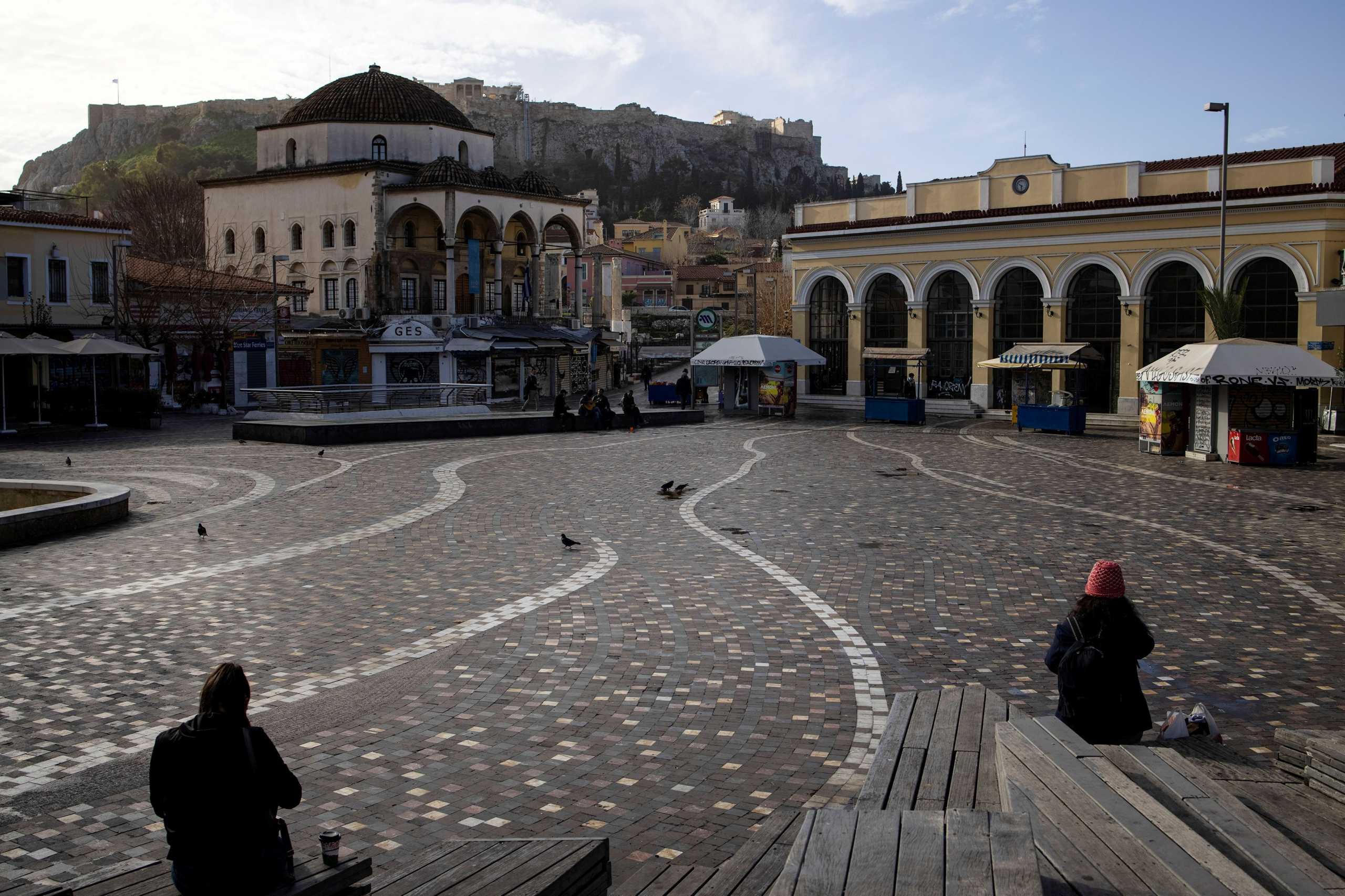 FILE PHOTO: People sit in Monastiraki square after the Greek government imposed stricter lockdown measures against the coronavirus pandemic, in Athens, Greece, February 11, 2021. REUTERS