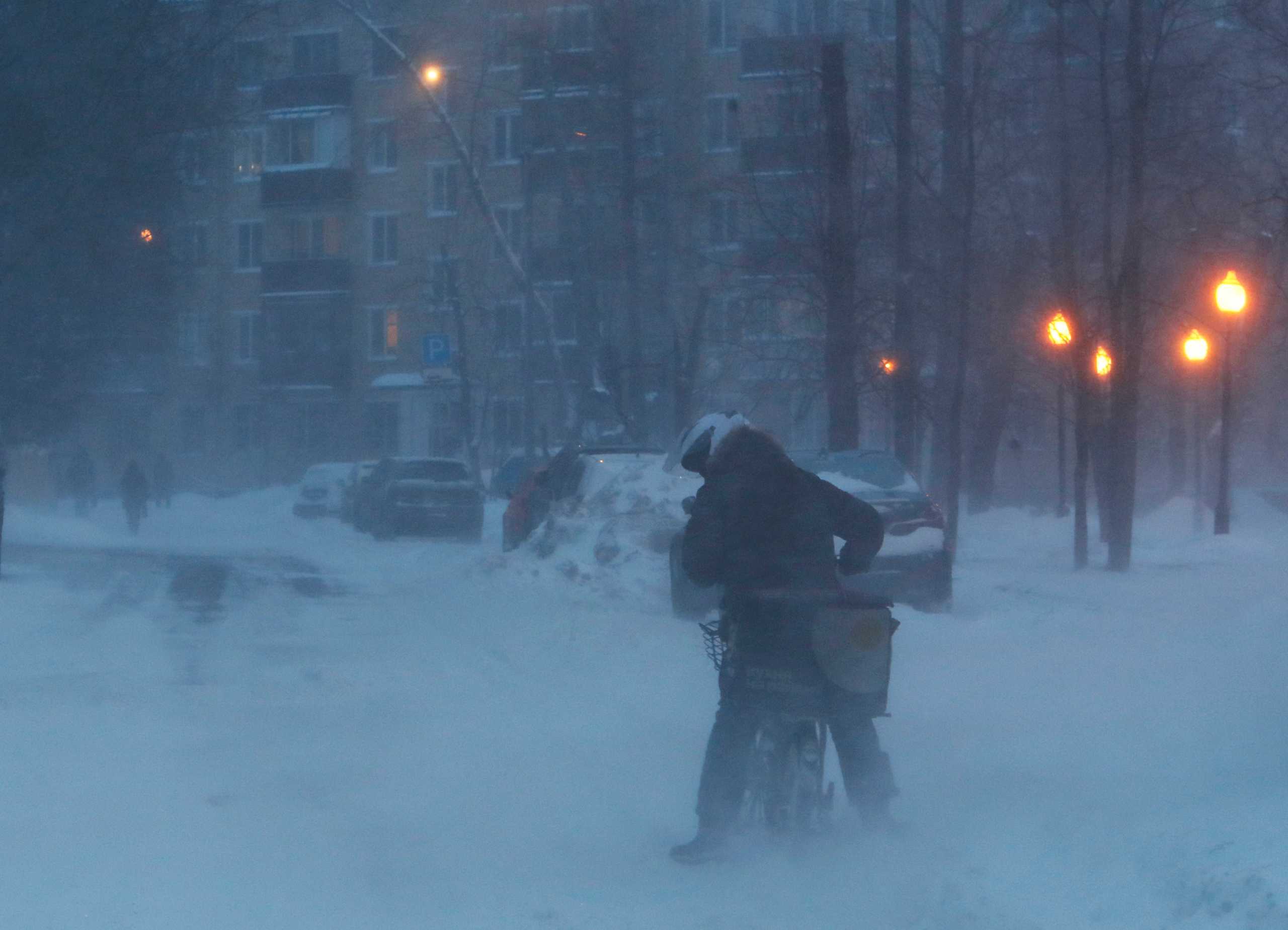 A person rides a bike during heavy snowfall in Moscow, Russia February 12, 2021. REUTERS