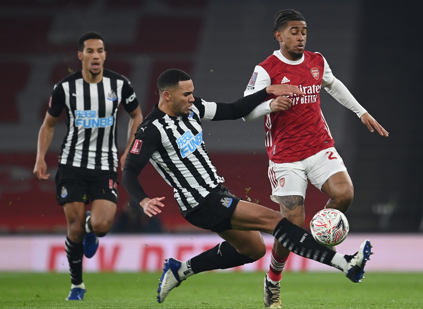 epa08928926 Reiss Nelson (R) of Arsenal in action against Jamaal Lascelles (C) of Newcastle during the English FA Cup third round soccer match between Arsenal and Newcastle United in London, Britain, 09 January 2021.  EPA