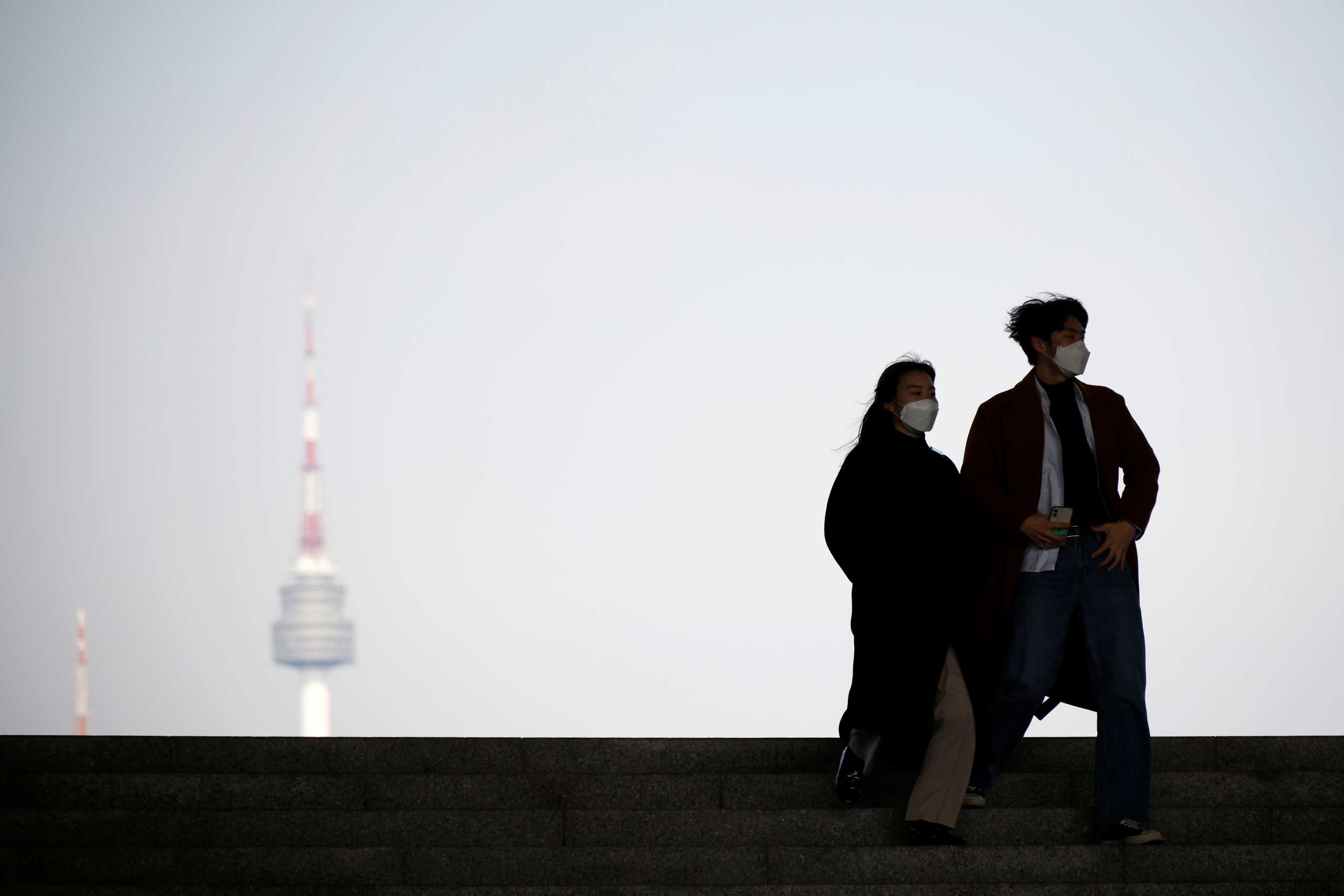 A couple walks as N Seoul Tower is seen in the background, amid the coronavirus disease (COVID-19) pandemic, at the National Museum of Korea in Seoul, South Korea, February 19, 2021.    REUTERS