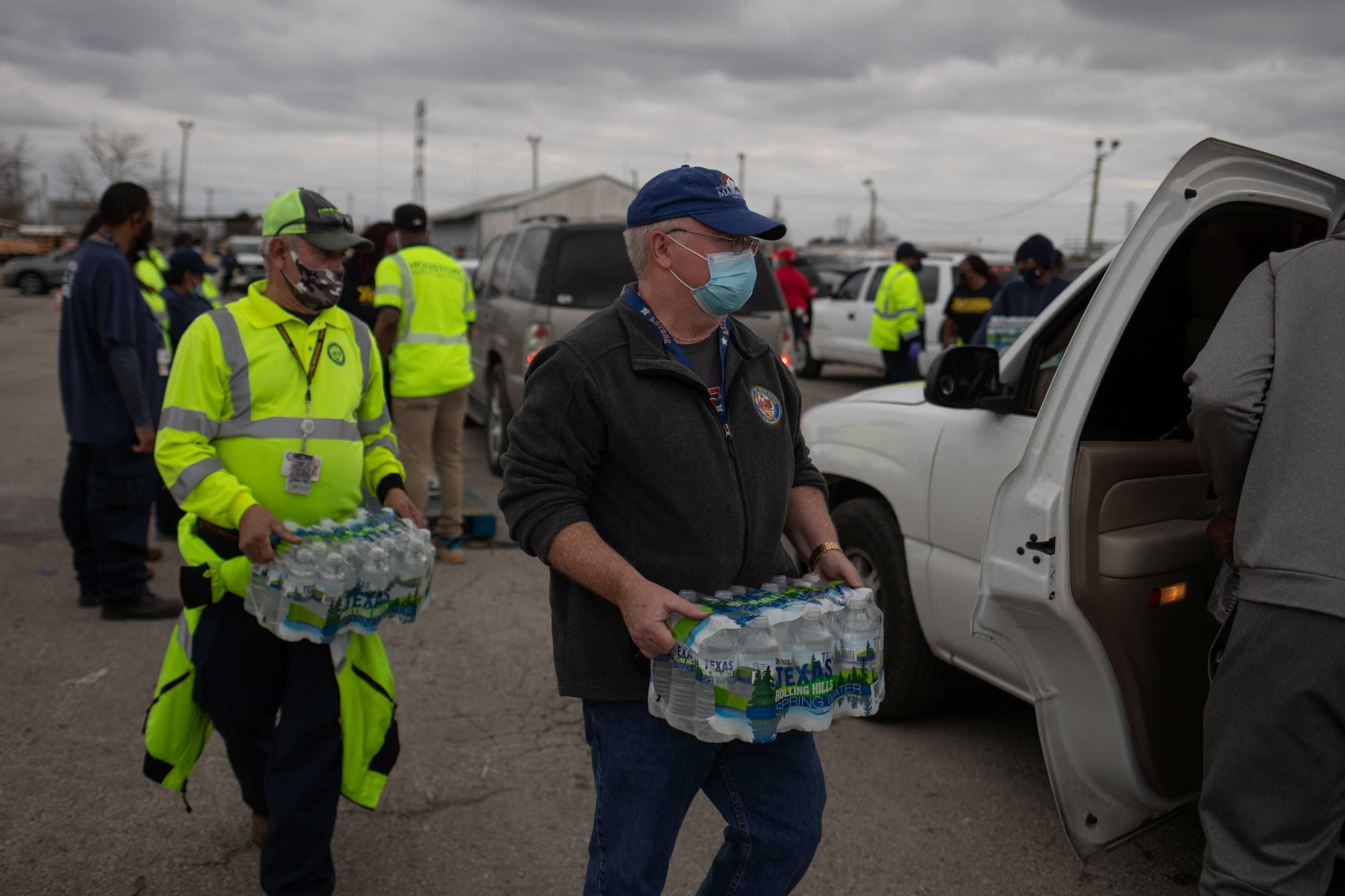 Volunteers deliver water to local residents in vehicles at Butler Stadium after an unprecedented winter storm in Houston, Texas, U.S., February 21, 2021. REUTERS