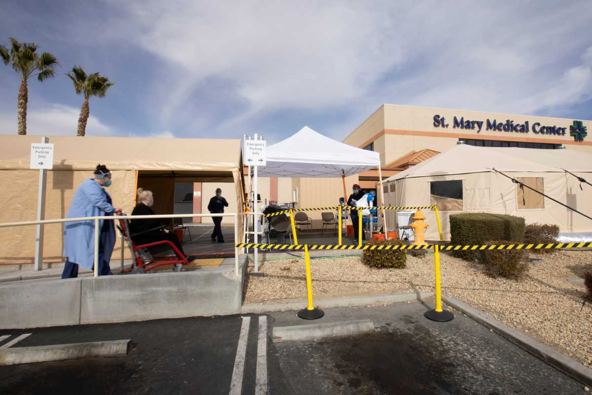 Healthcare workers attend to a patient as St. Mary Medical Center resorts to using triage tents outside to handle the overflow at its 200 bed hospital during the outbreak of the coronavirus disease (COVID-19) in Apple Valley, California, U.S., January 12, 2021. REUTERS