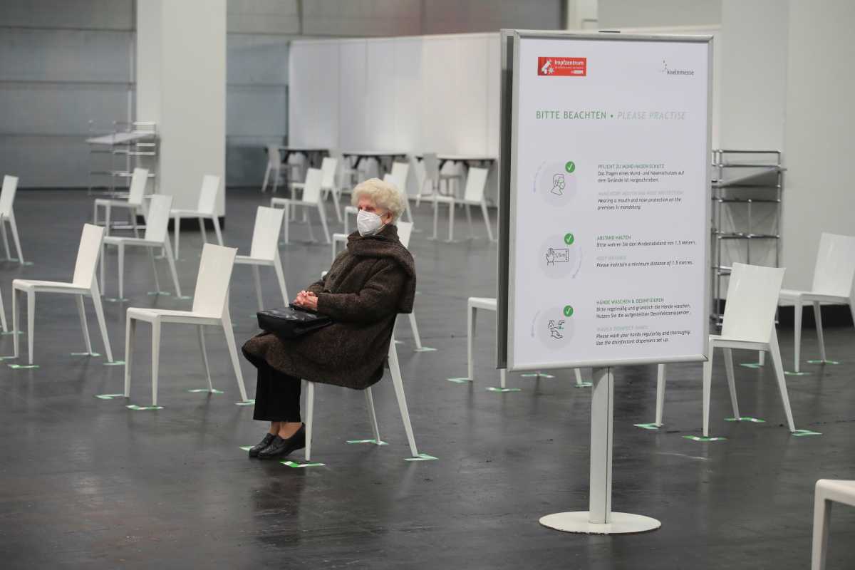 An elderly woman wearing a protective face mask waits to receive the Pfizer-BioNTech COVID-19 vaccine, at a vaccination centre temporarily set up in a hall of the fair of Cologne, Germany, February 8, 2021. REUTERS
