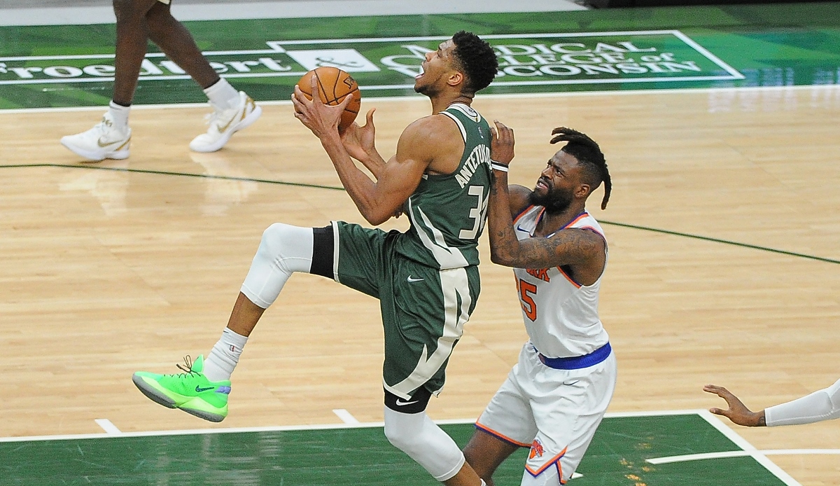 Mar 11, 2021; Milwaukee, Wisconsin, USA;  Milwaukee Bucks forward Giannis Antetokounmpo (34) is fouled by New York Knicks forward Reggie Bullock (25) in the third quarter at Fiserv Forum. Mandatory Credit: Michael McLoone-USA TODAY Sports