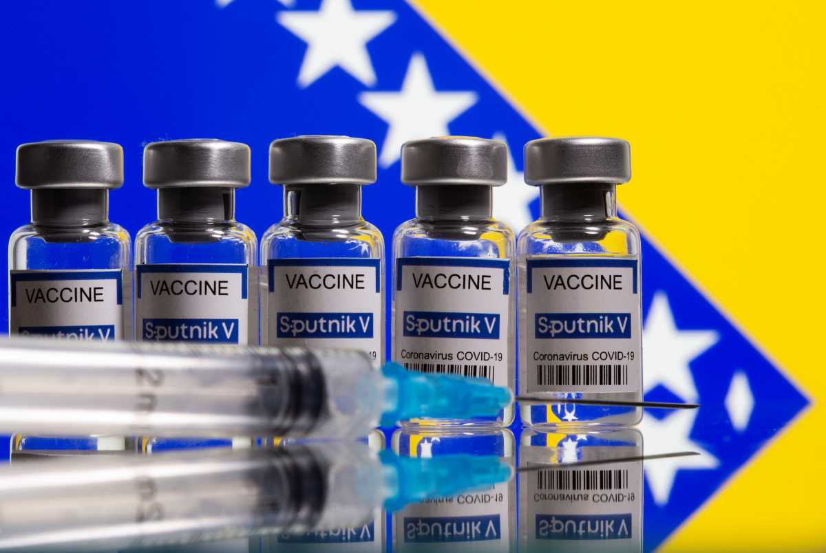 Vials labelled "Sputnik V coronavirus disease (COVID-19) vaccine" and a syringe are seen in front of a displayed Bosnian flag in this illustration picture taken March 17, 2021. REUTERS