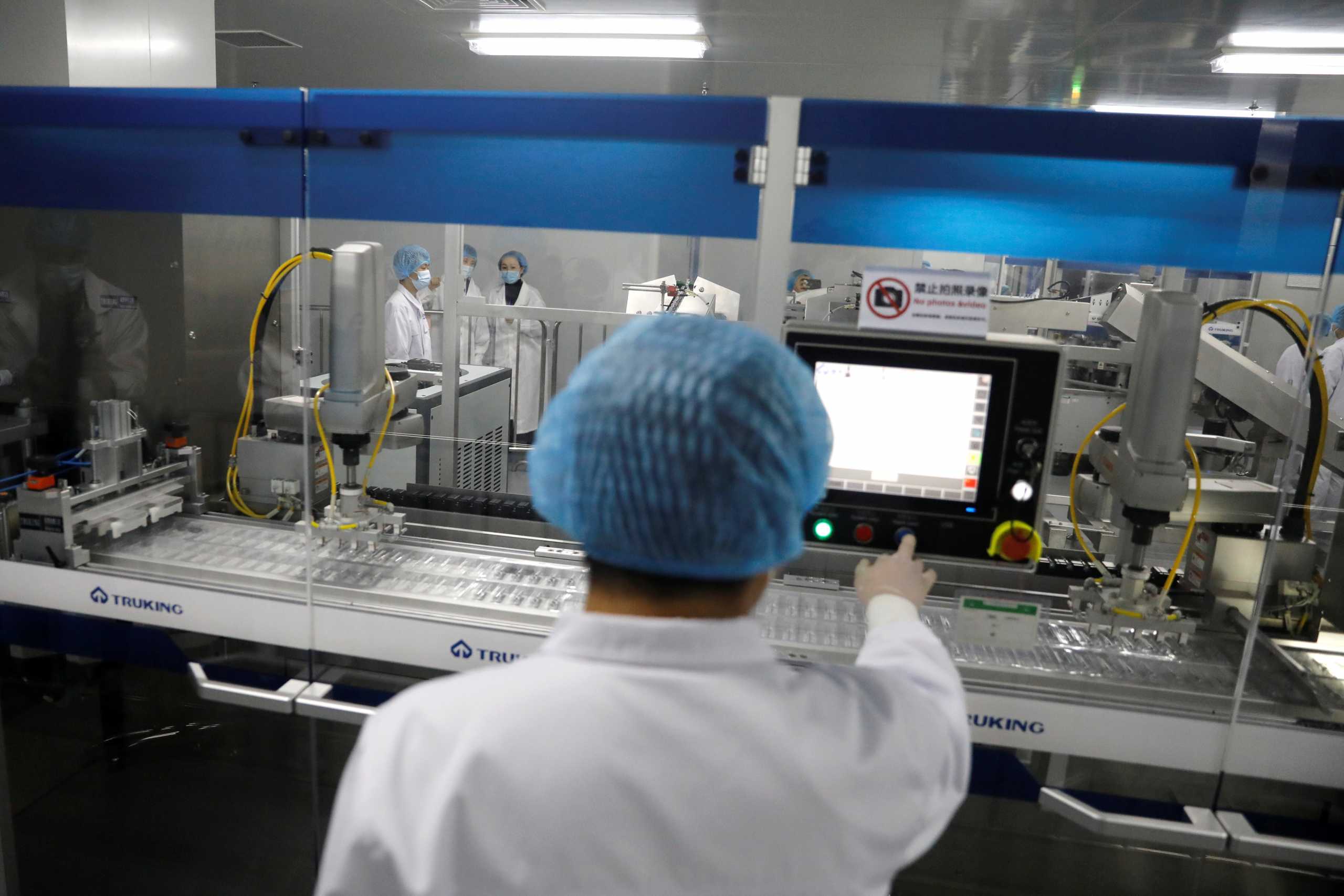 A staff member works next to a production line of COVID-19 vaccine inside the Beijing Institute of Biological Products of Sinopharm's China National Biotec Group (CNBG), during a government-organised visit to the company in Beijing, China February 26, 2021. REUTERS
