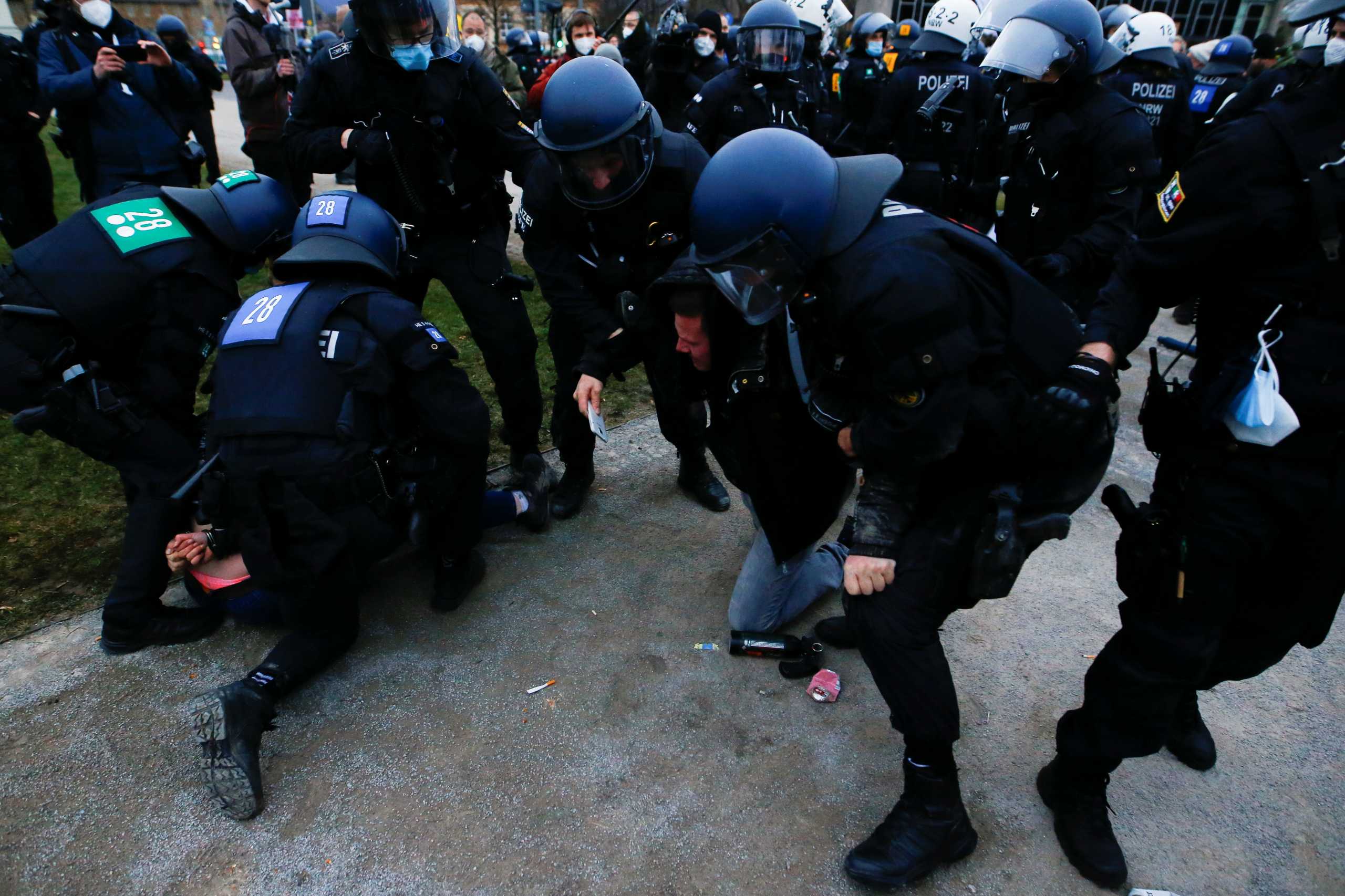Police officers remove demonstrators from a square during a protest against the government's coronavirus disease (COVID-19) restrictions in Kassel, Germany March 20, 2021. REUTERS