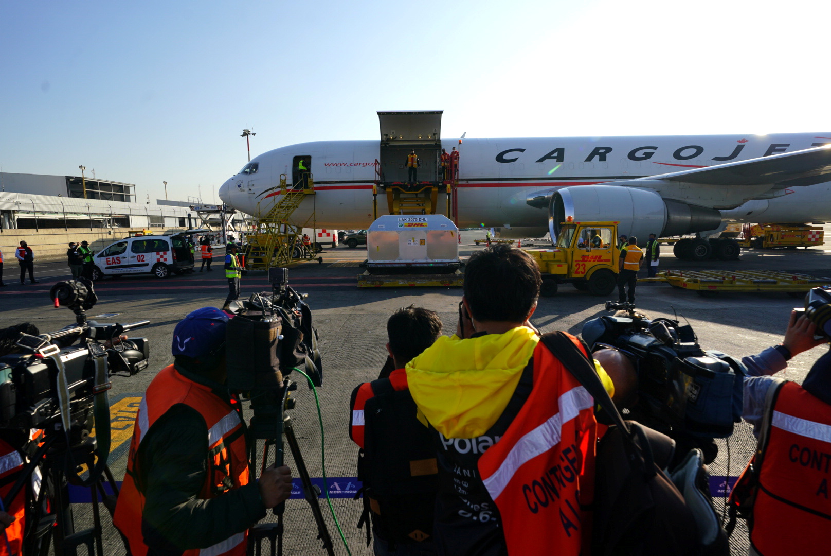 Airline employees unload a container with a batch of the AstraZeneca's COVID-19 vaccine, at the Benito Juarez International Airport, in Mexico City, Mexico March 16, 2021. Mexico Presidency